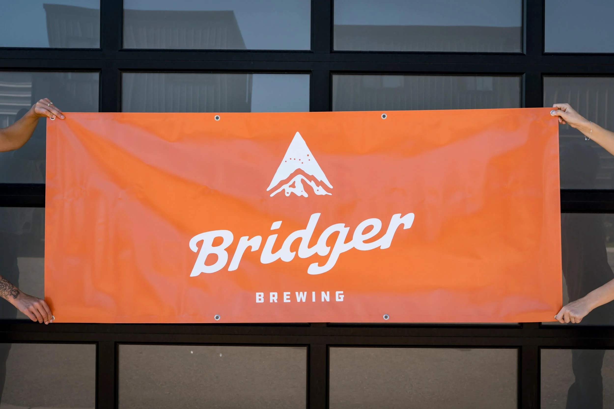 Bright orange vinyl banner with Brider Brewing logo