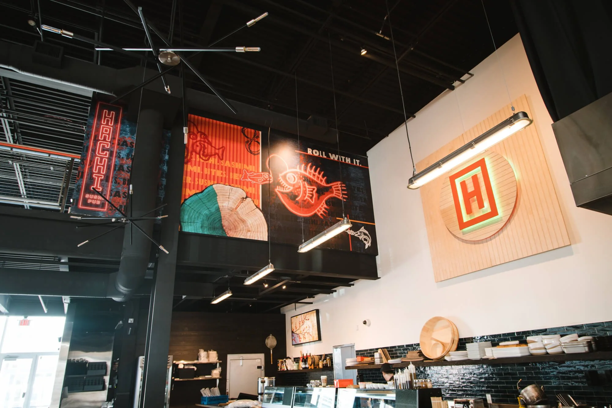Modern sushi bar interior wall wrap with neon fish design by Wrap Agency for Hachi Sushi Pub in Bozeman, Montana.