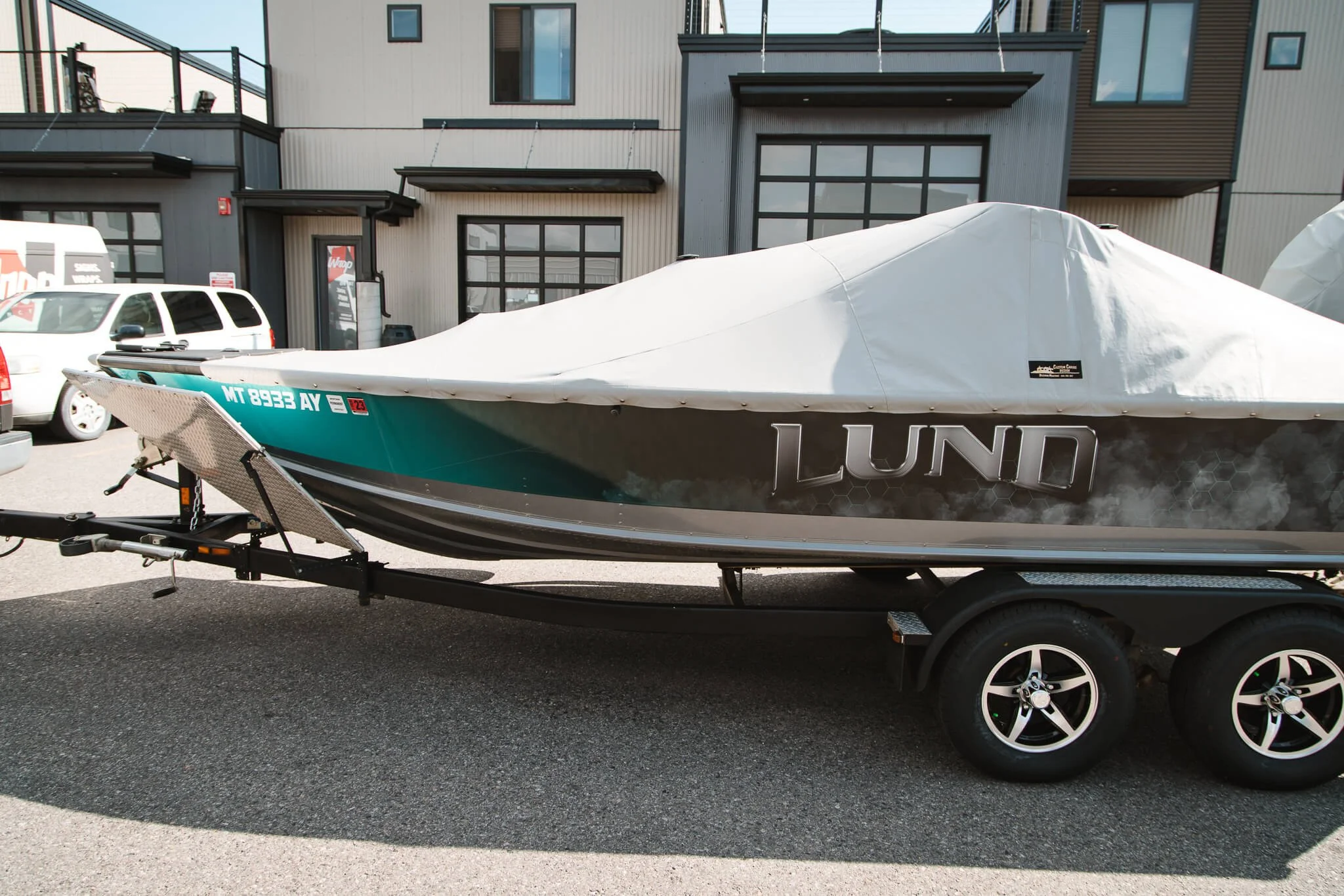 Side profile of a LUND boat showing off a full-body custom vinyl wrap in metallic tones with turquoise accents.