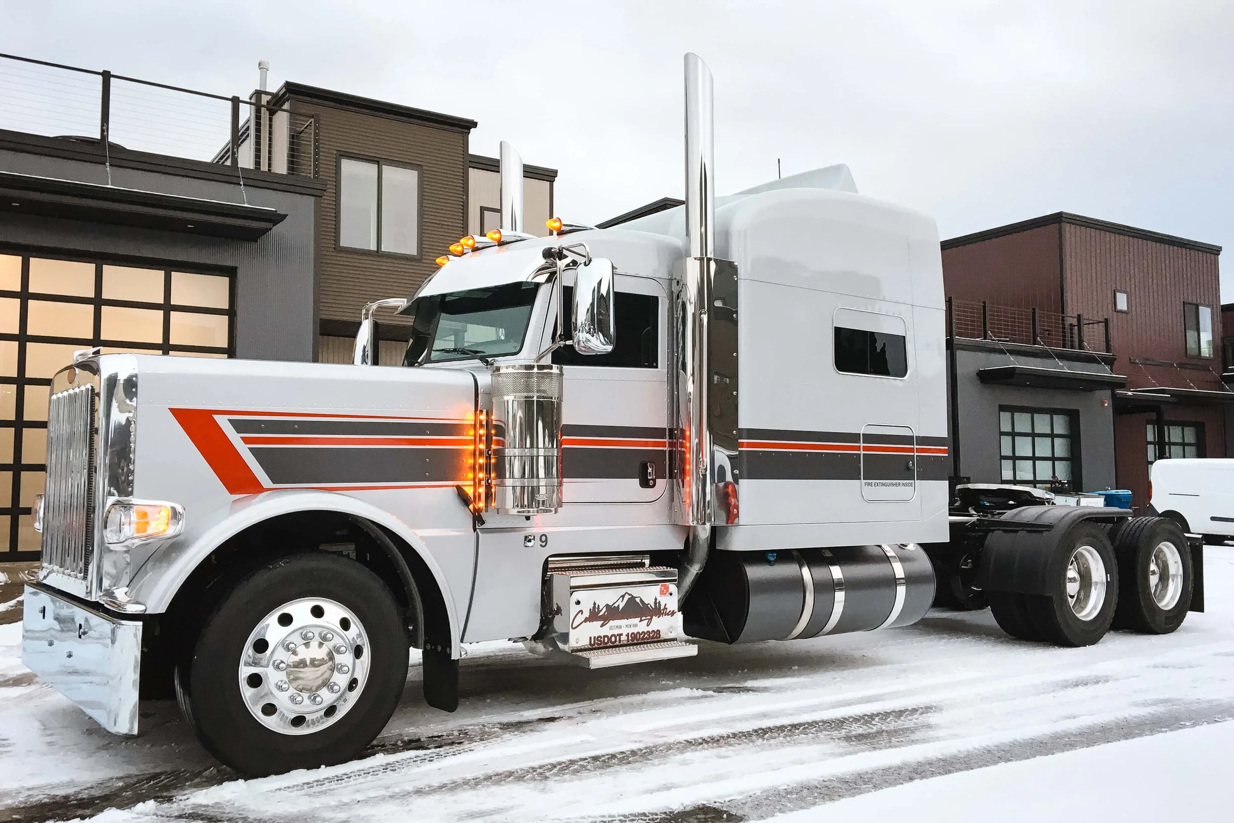 High-shine chrome semi truck with red, gray, and black vinyl graphics creating a bold and dynamic fleet wrap look that reflects the business’s rugged identity. Location: Bozeman, Montana.