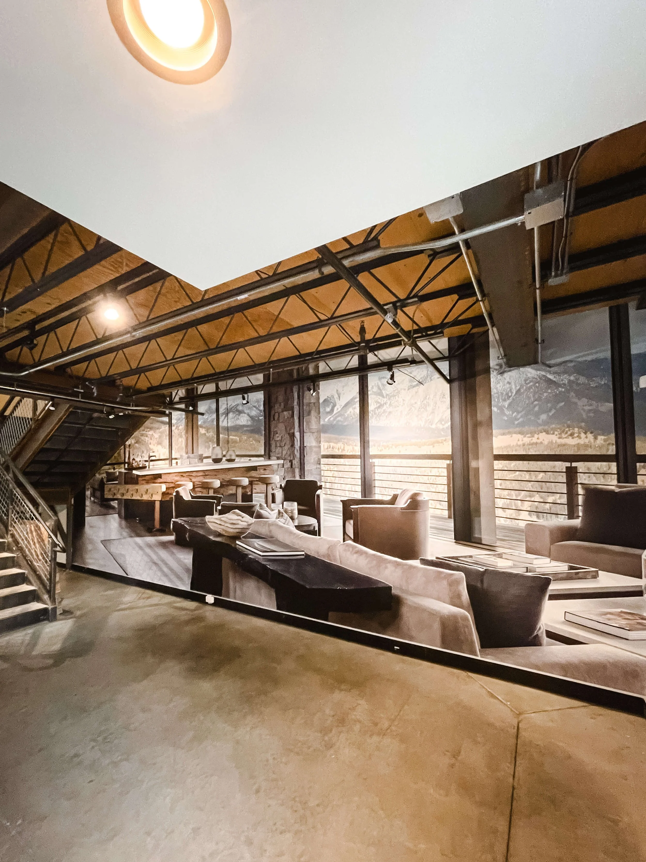 Photorealistic wall wrap simulating an open, modern lounge space with panoramic mountain views, applied to an interior lobby or hallway – installed at Highline Partners in Bozeman, MT.