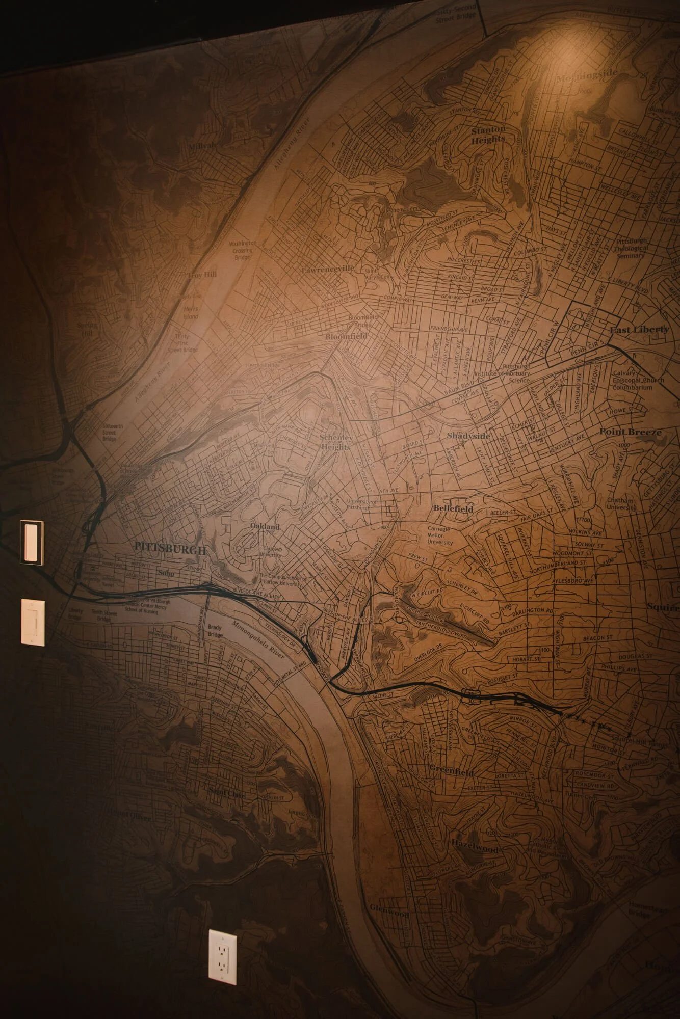 Sepia-toned wall wrap map of Pittsburgh featuring detailed street and topography lines, creating a vintage atmosphere in a commercial or residential space at a residential home in Bozeman, MT.