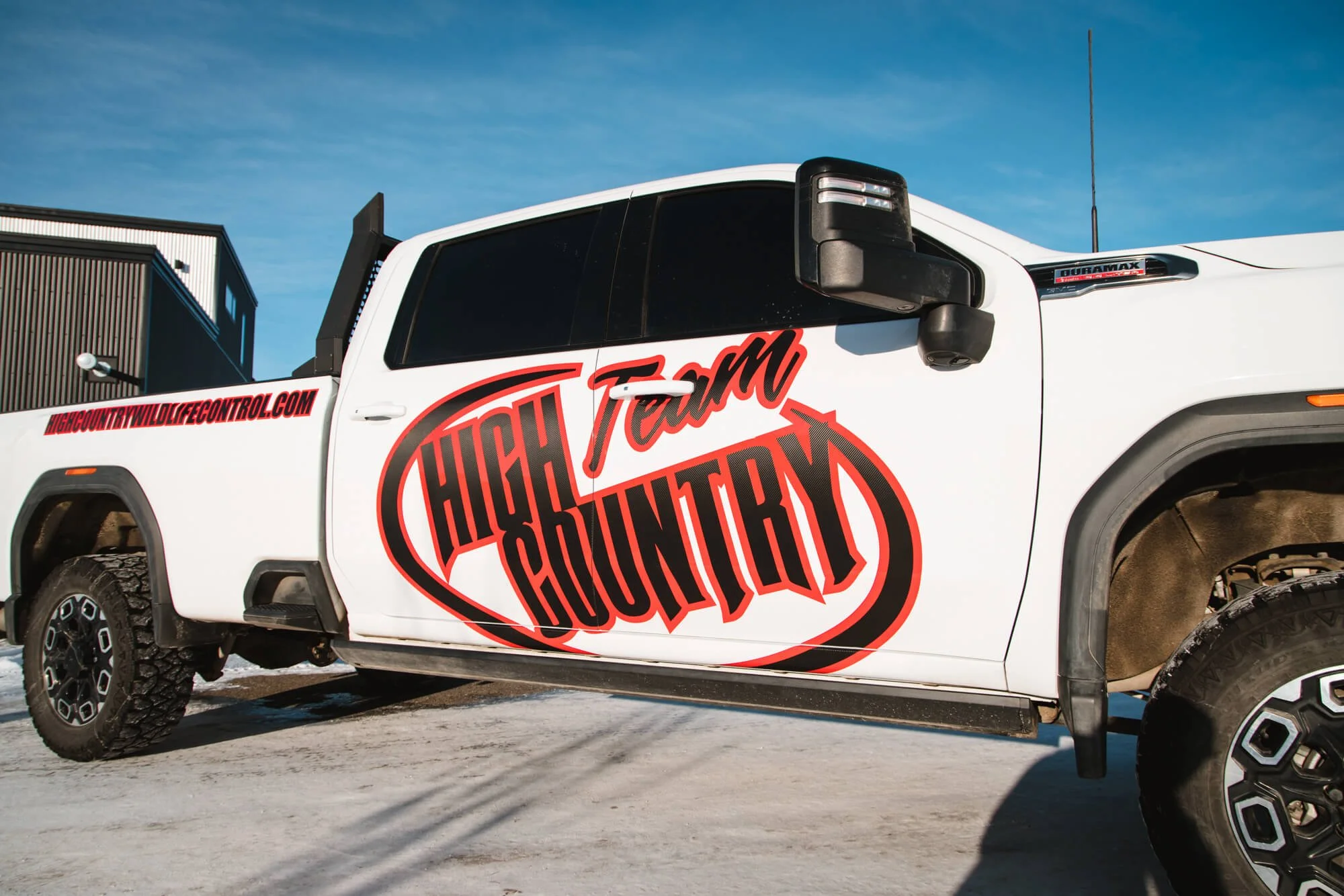 White pickup truck with "High Country Team" vinyl decal on the door in Bozeman, Montana