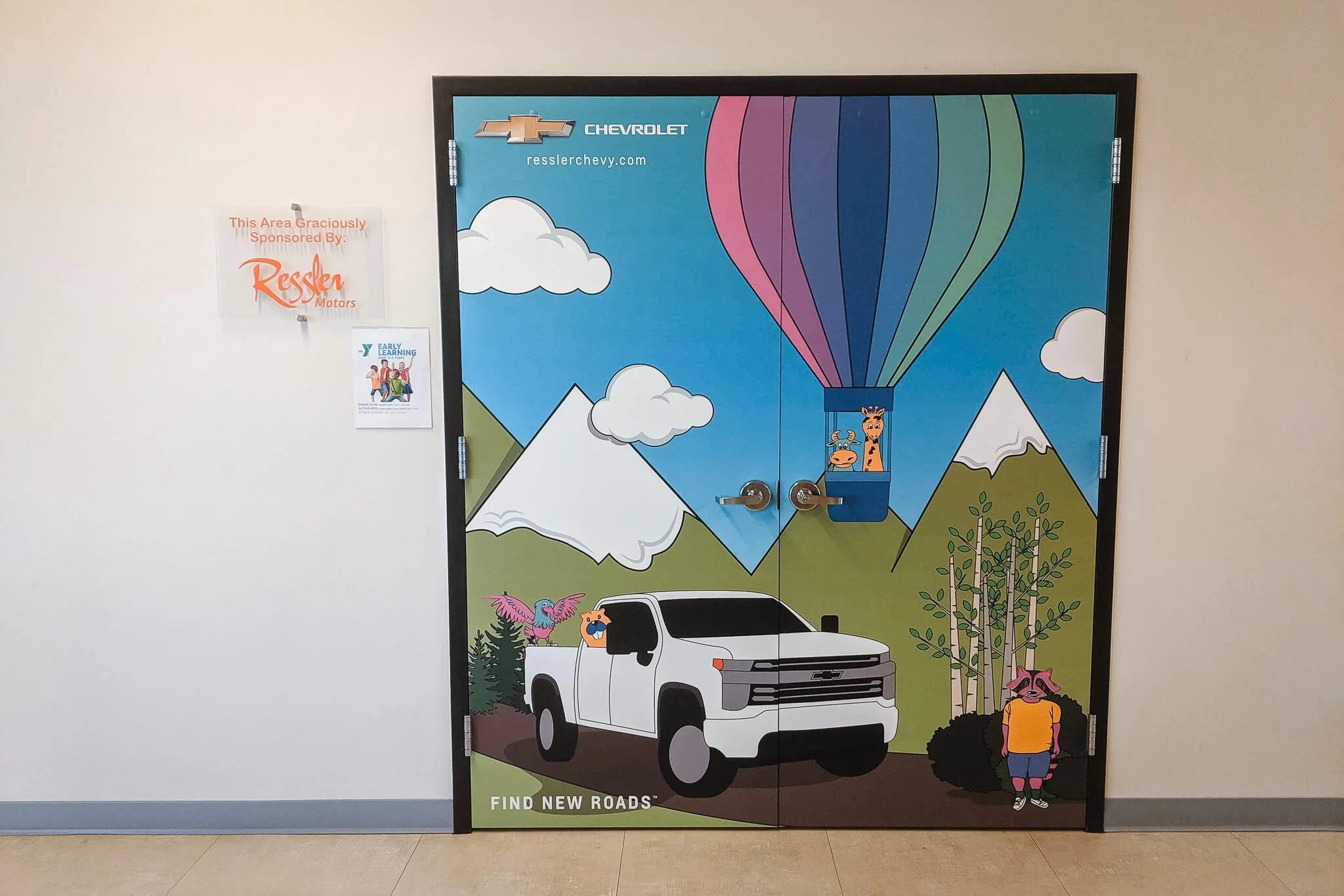 Full wraps on a set of double doors with a cartoon landscape scene with a large hot air ballon on the right side. Includes Chevrolet branding
