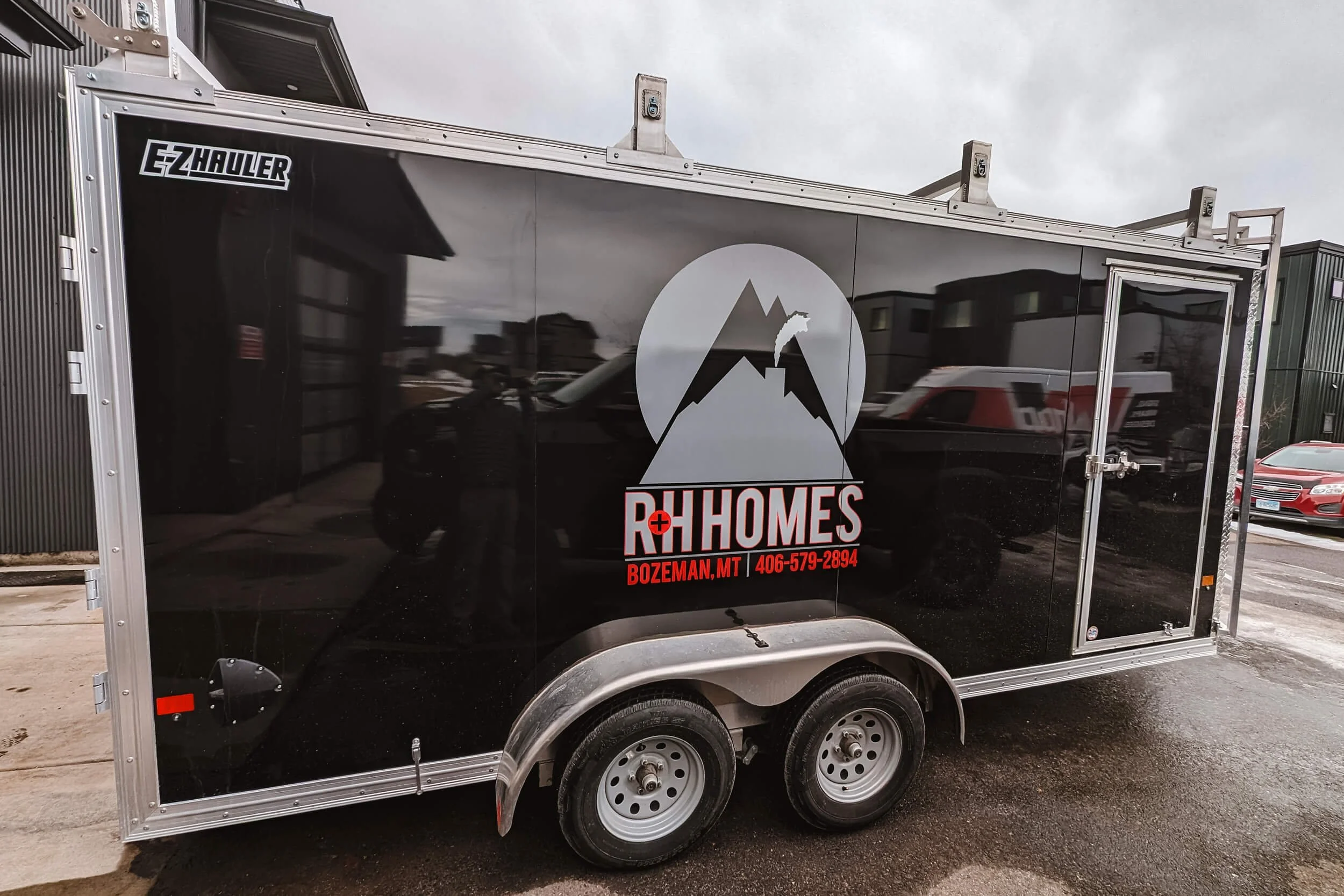 R&H Homes logo centered over the wheel well on the side of a trailer in Bozeman, MT