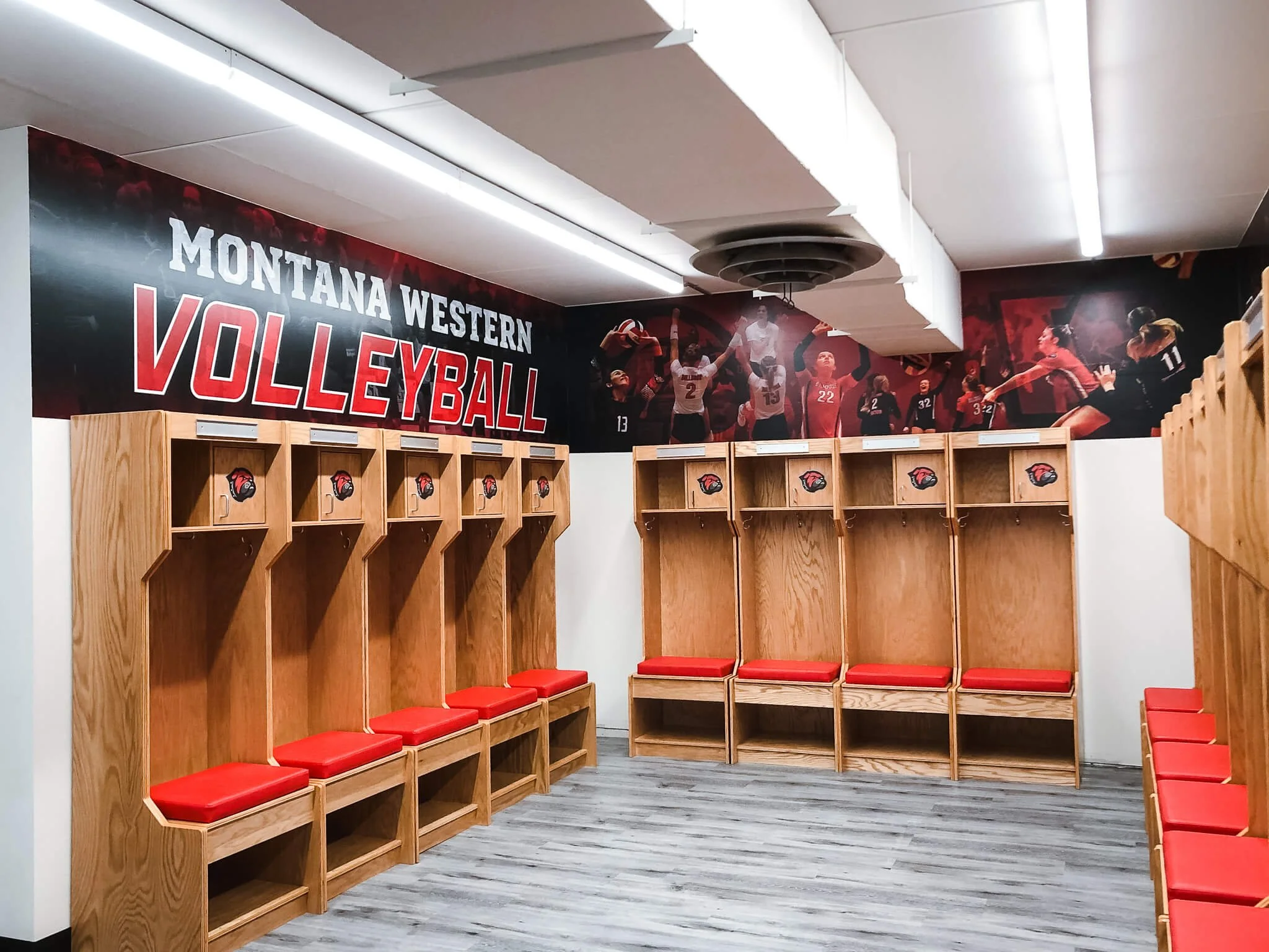 Montana Western volleyball locker room decorated with team images and branding.