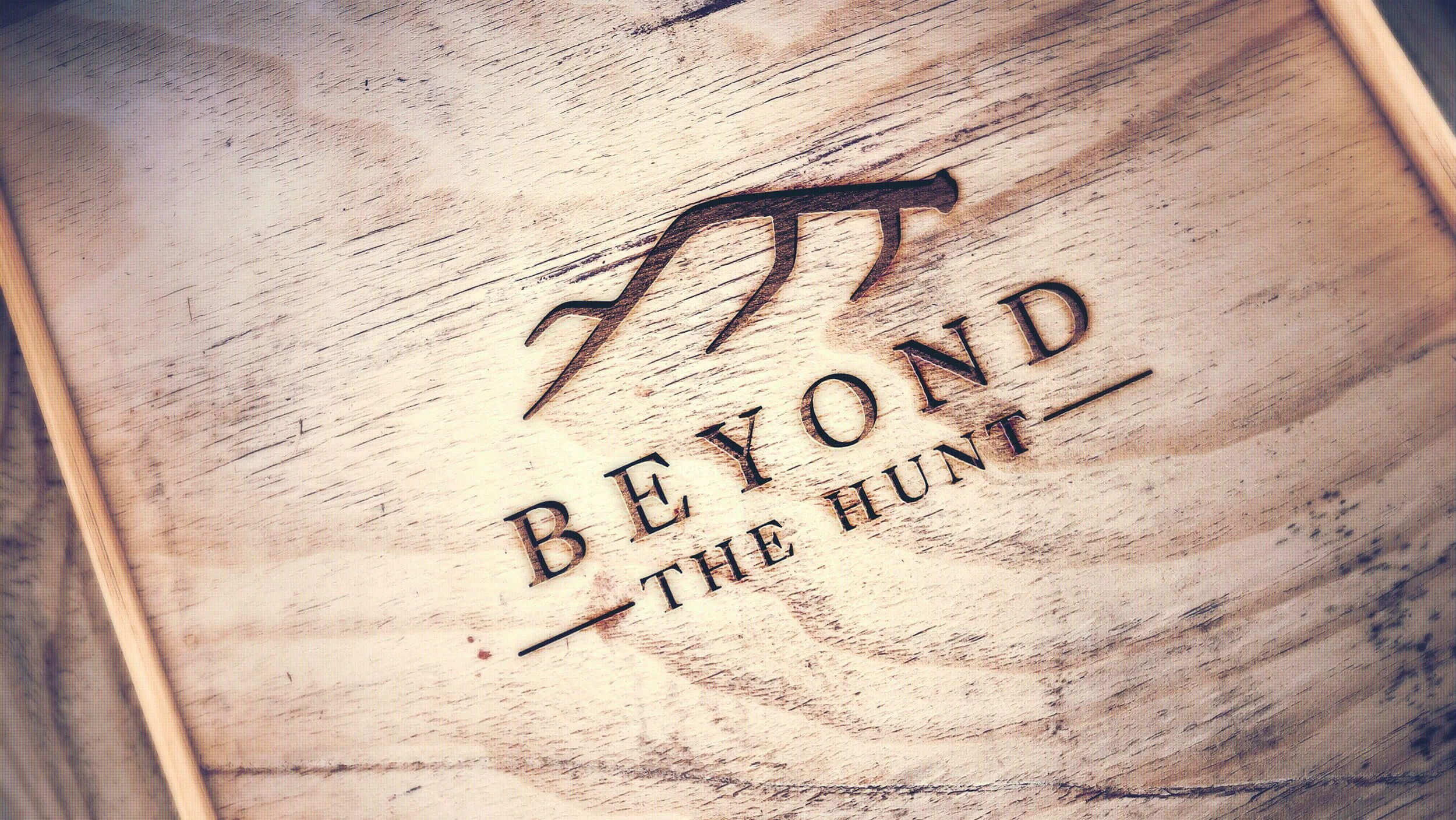 Beyond The Hunt logo engraved on wood with stylized antlers design.
