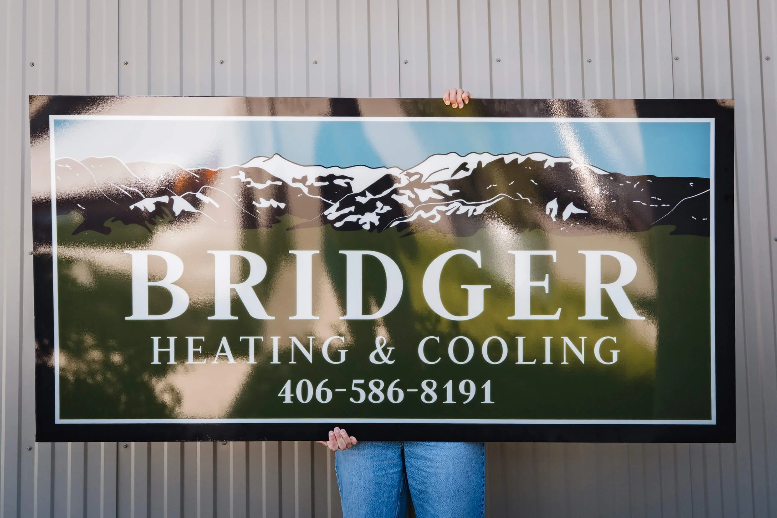 Backlit sign for Bozeman's Bridger Heating & Cooling. Features an illustration of the Bridger Mountain range. 