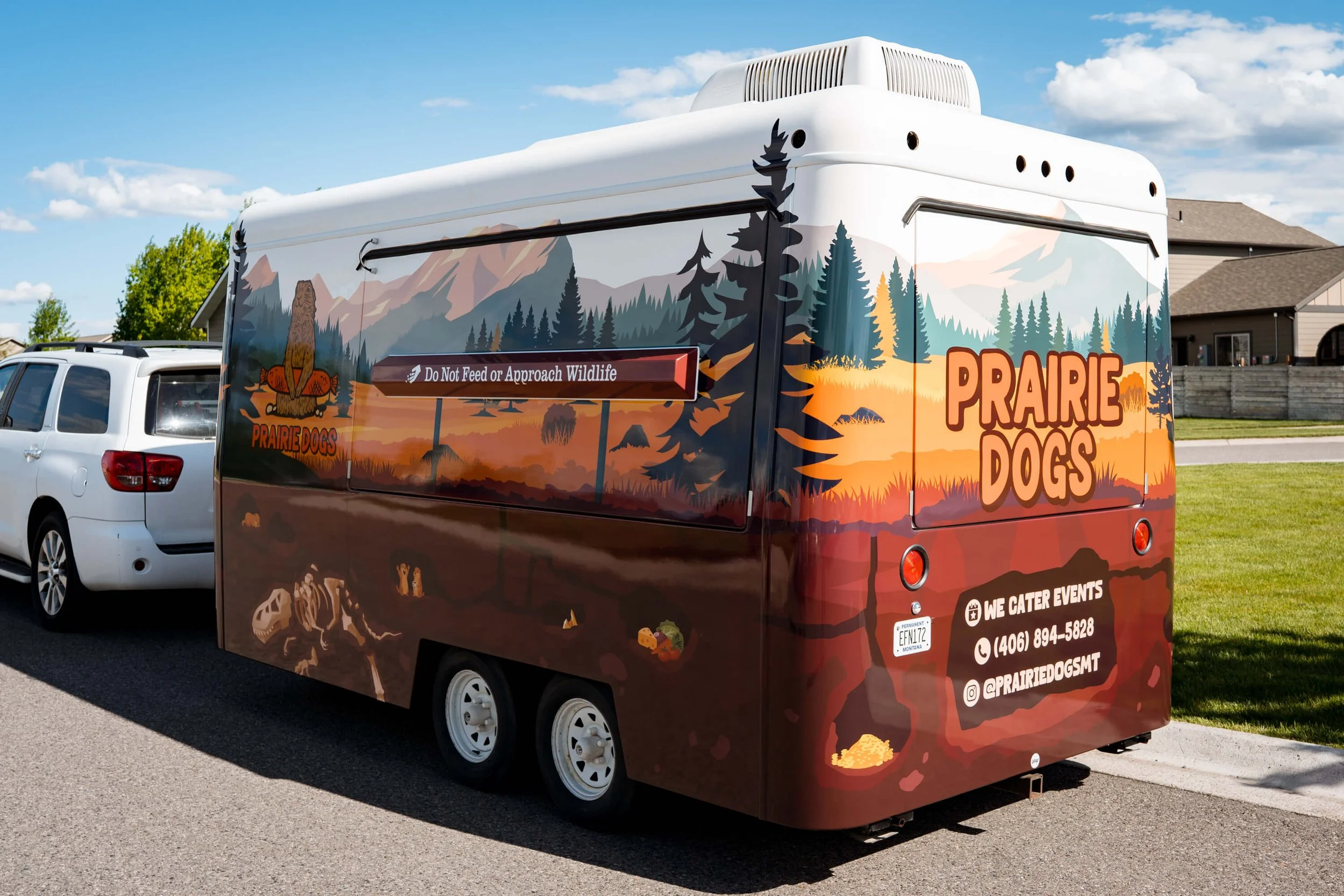 Full trailer wrap with forest and prairie dog-themed trailer graphics for Prairie Dogs catering in Bozeman, Montana, featuring a scenic landscape, mountain backdrop, and bold brand name on the back panel. 