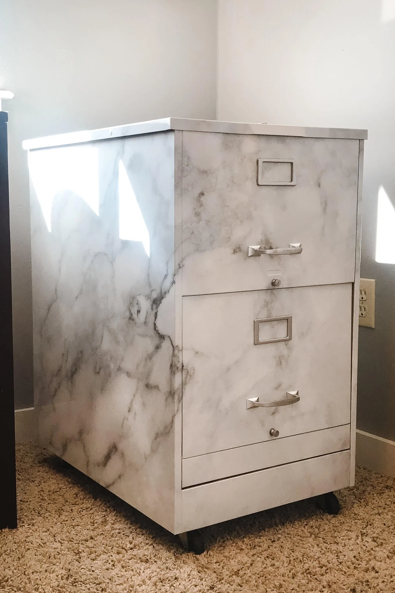Elegant marble-patterned filing cabinet transformed with custom vinyl wraps, giving a sleek and modern aesthetic for office or home decor.