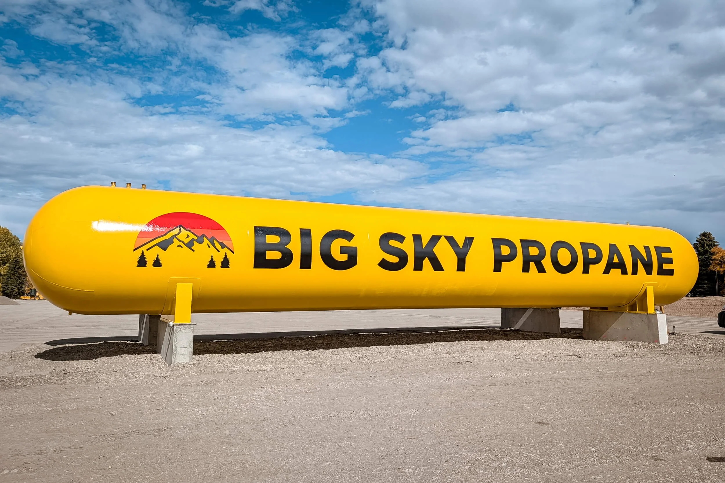30,000 gallon bright yellow propane tank with large vinyl graphics reading Big Sky Propane with their logo