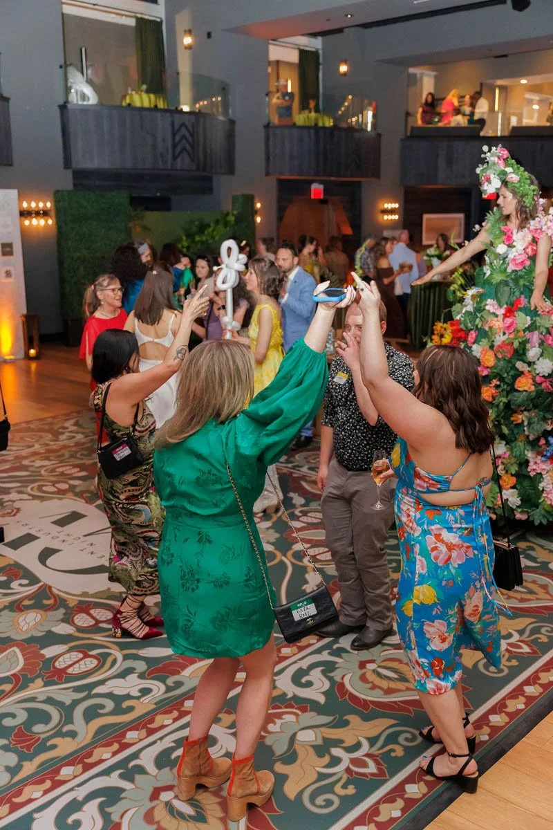 Guests dancing on a colorful 21’ x 21’ custom dance floor wrap with a rug-style print at the Armory Hotel in Bozeman, MT. Designed in-house by The Wrap Agency. Photo by Kristen Rose Photography.