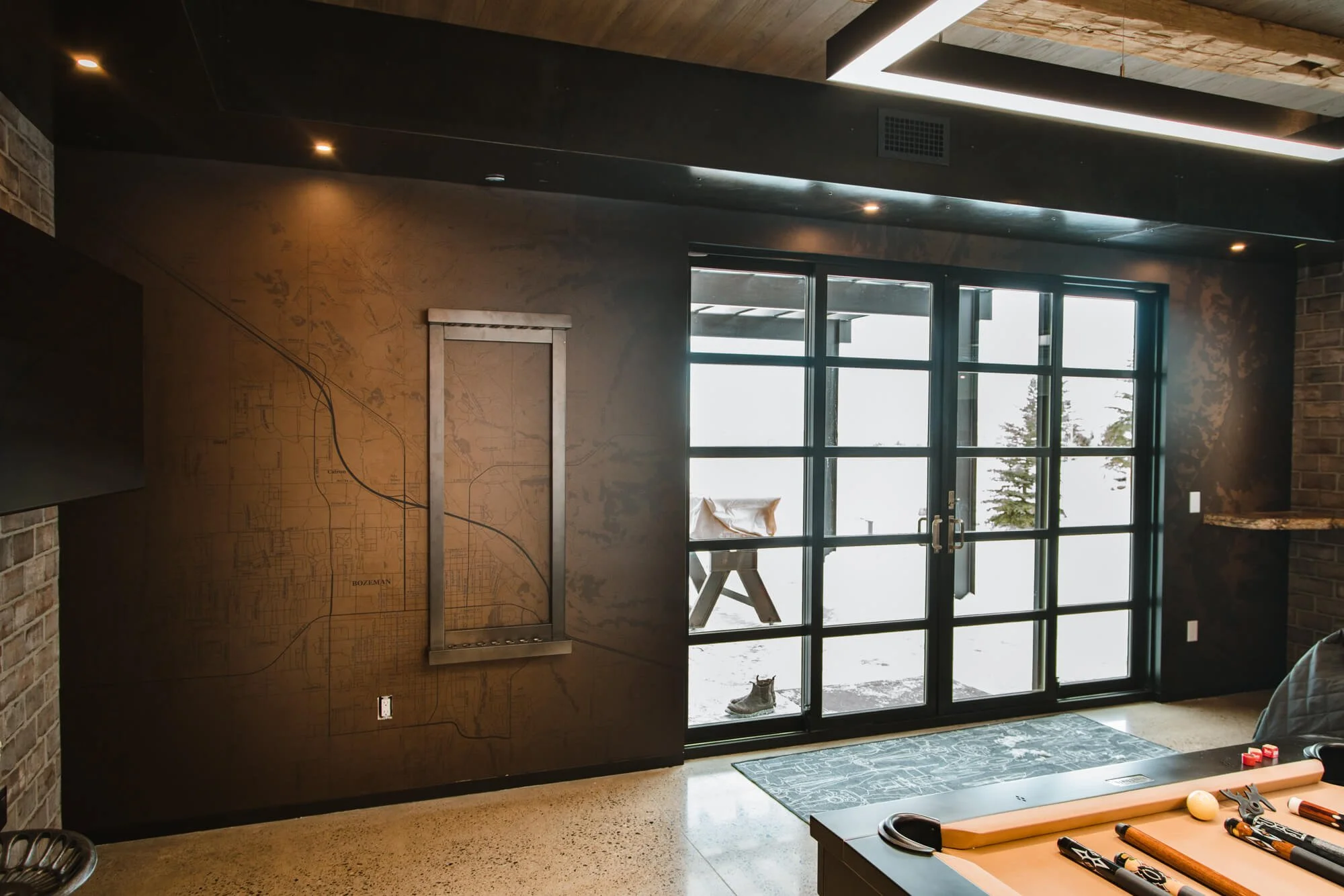 Custom map wall wrap showing detailed layout of Bozeman and surrounding area, used as a dramatic backdrop in a modern rec room or office at a residential home in Bozeman, MT.