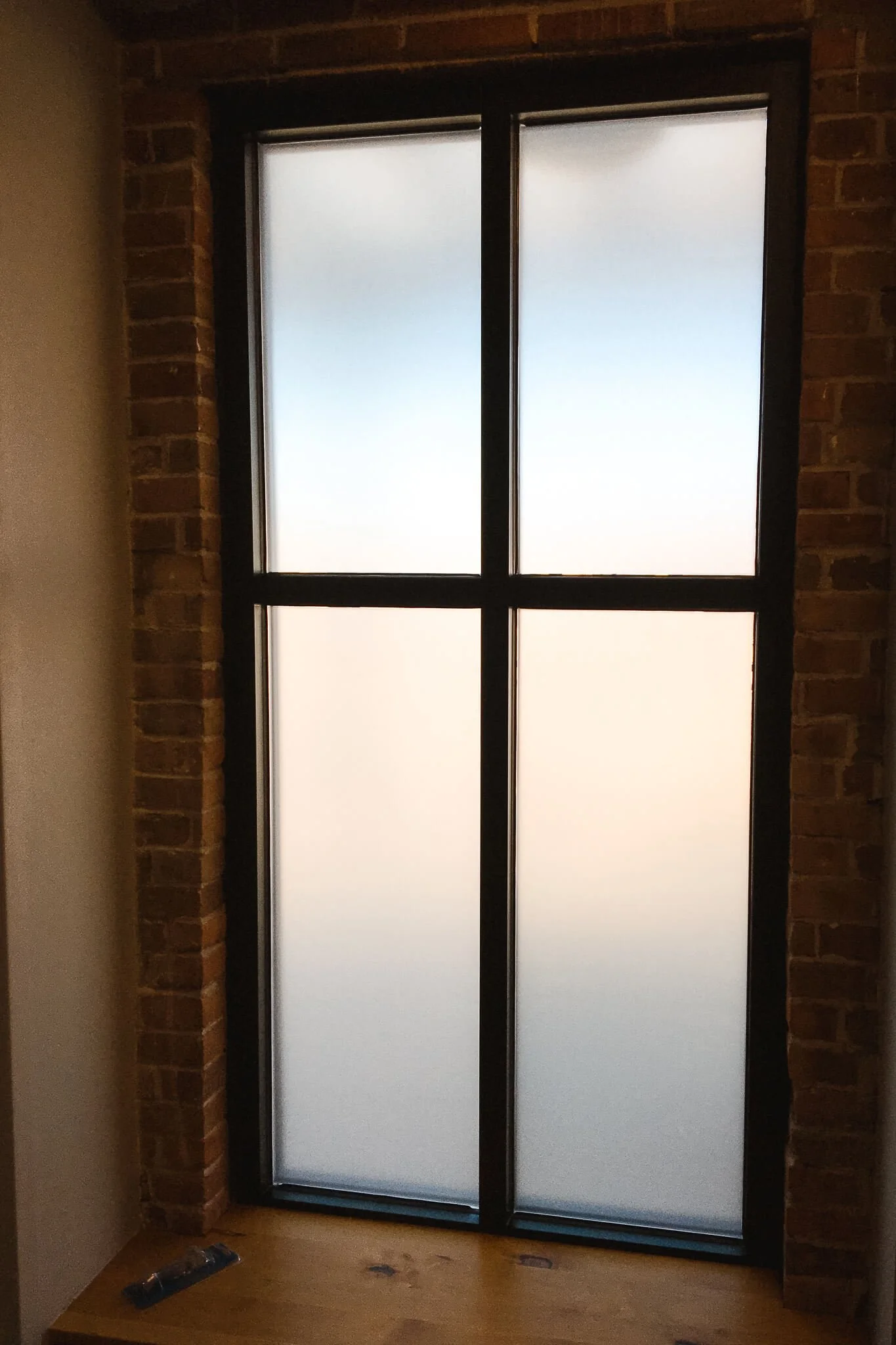 Frosted privacy window graphics applied to tall residential-style windows, softly diffusing natural light while maintaining a clean, minimal appearance.