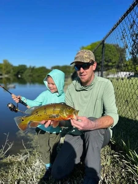 Maine Fishing Guide Brandon Bichrest and son Everett Bichrest with a Peacock Bass caught from the shore in Florida