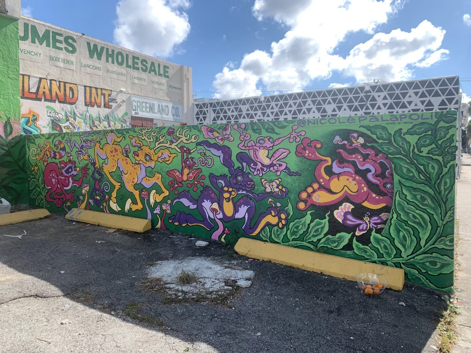 Mural by Nicole Palapoli: botanical mural along a parking lot wall