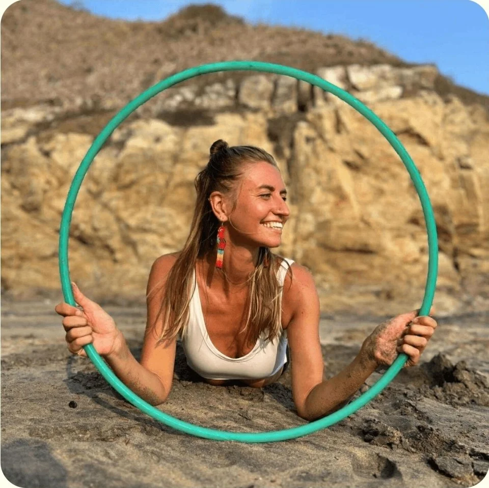 a girl and her hoop on the beach