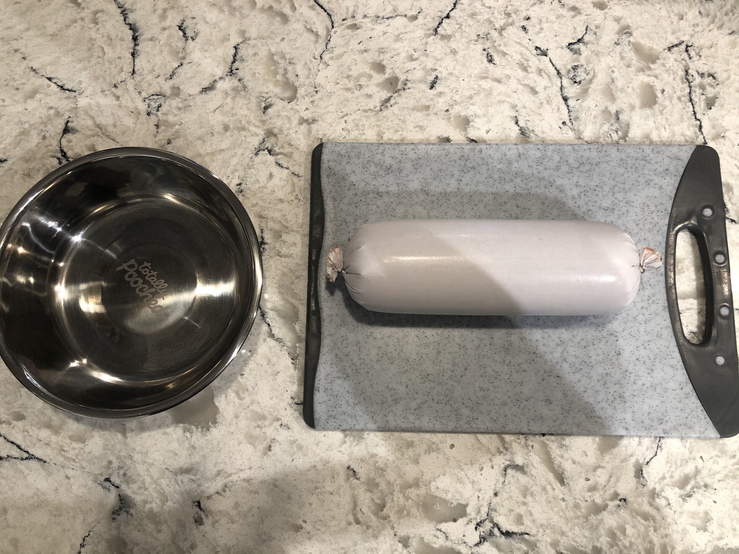 A tube of Markus’ raw Chicken, Bone & Vegetable from CRUDO on a cutting board