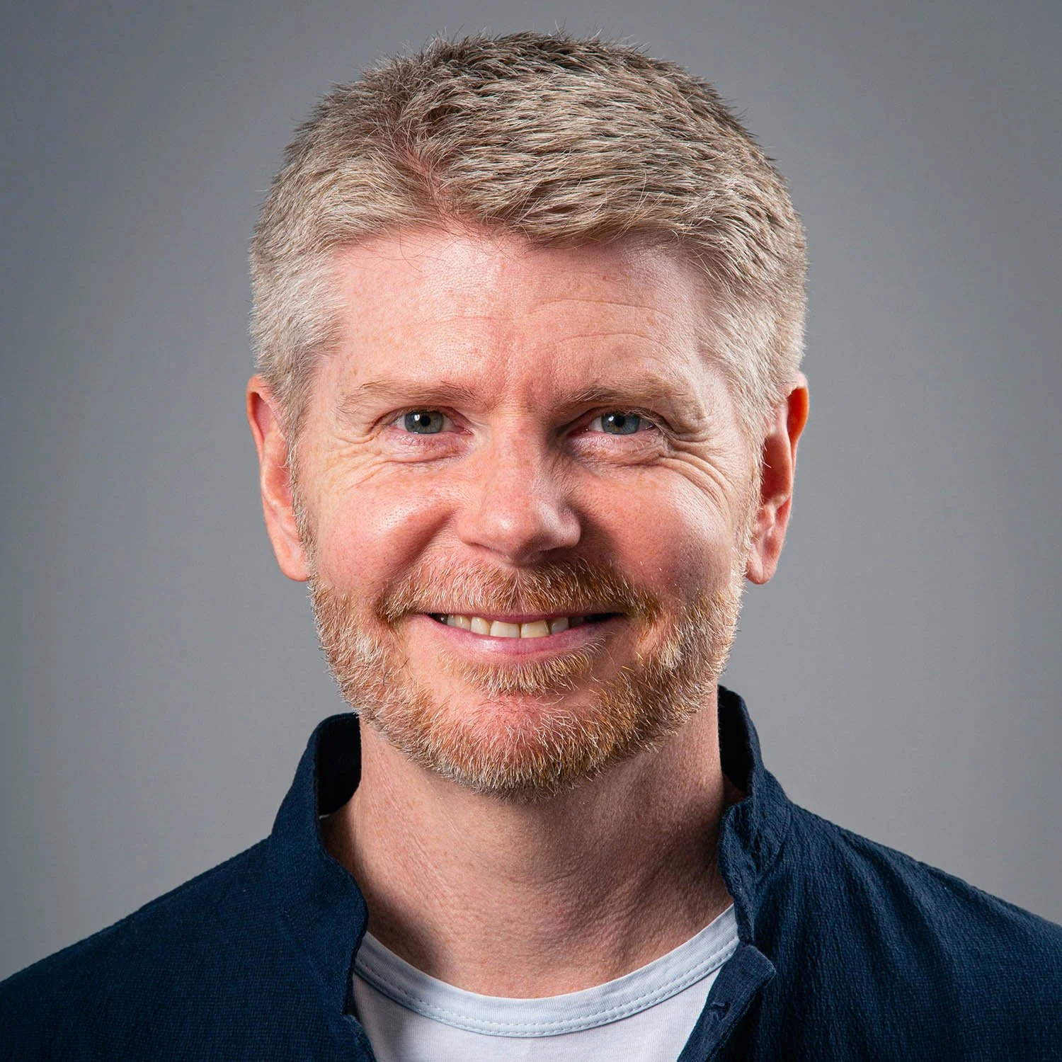 Greg Mathers, co-founder of Studio CMA, smiling in a relaxed professional portrait.