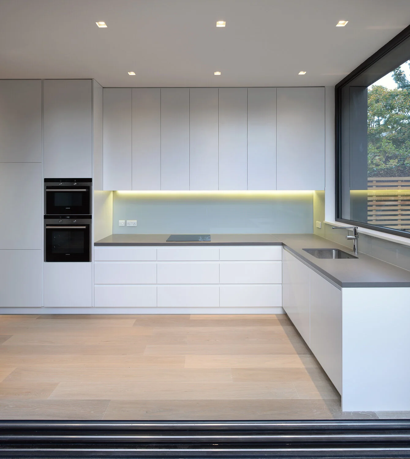Contemporary London kitchen with integrated storage, lighting and garden connection.