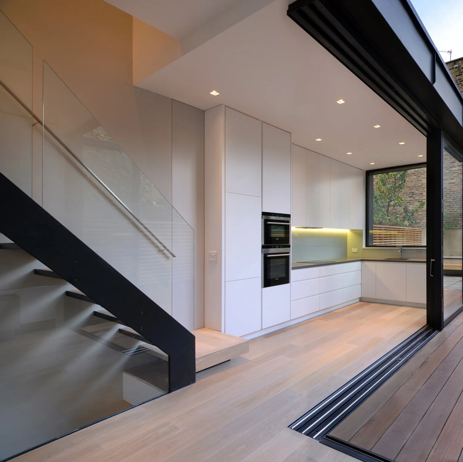 Kitchen and dining space within a rear extension, with the stair visible as part of a whole-house reorganisation.