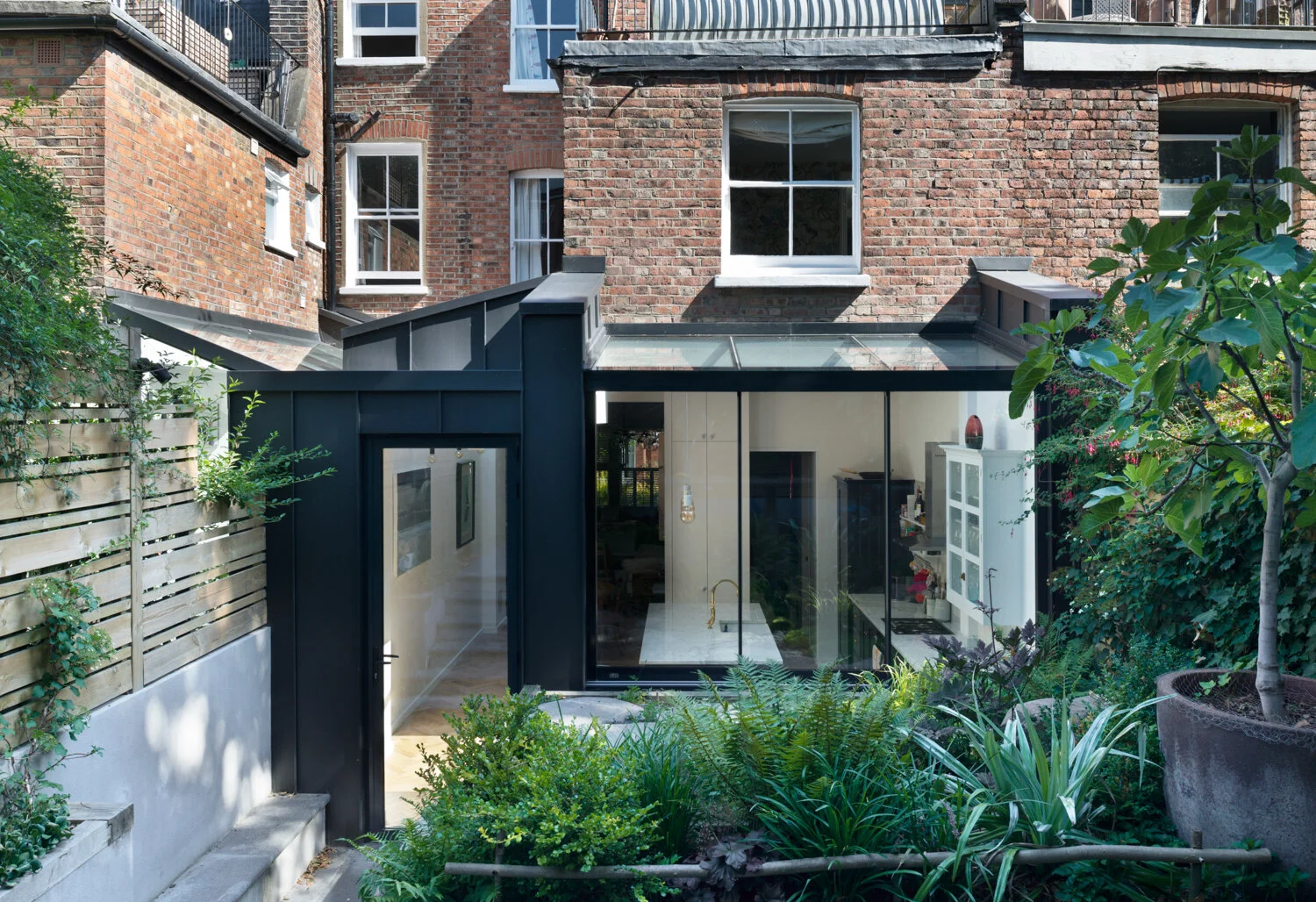Contemporary rear wraparound extension to a Victorian terrace with landscaped garden in Islington
