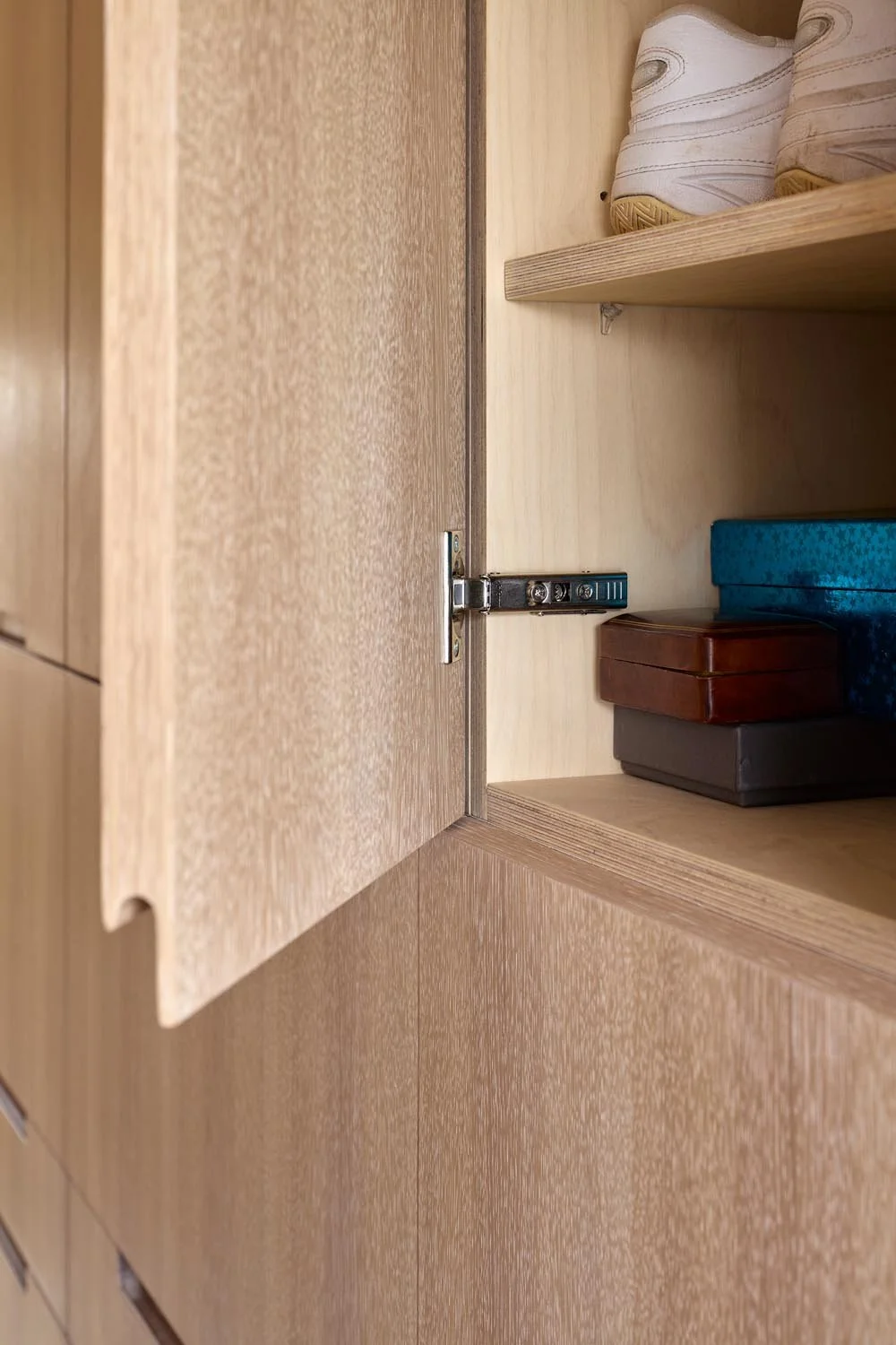 Bespoke oak cabinet door with recessed handle and concealed storage detail.