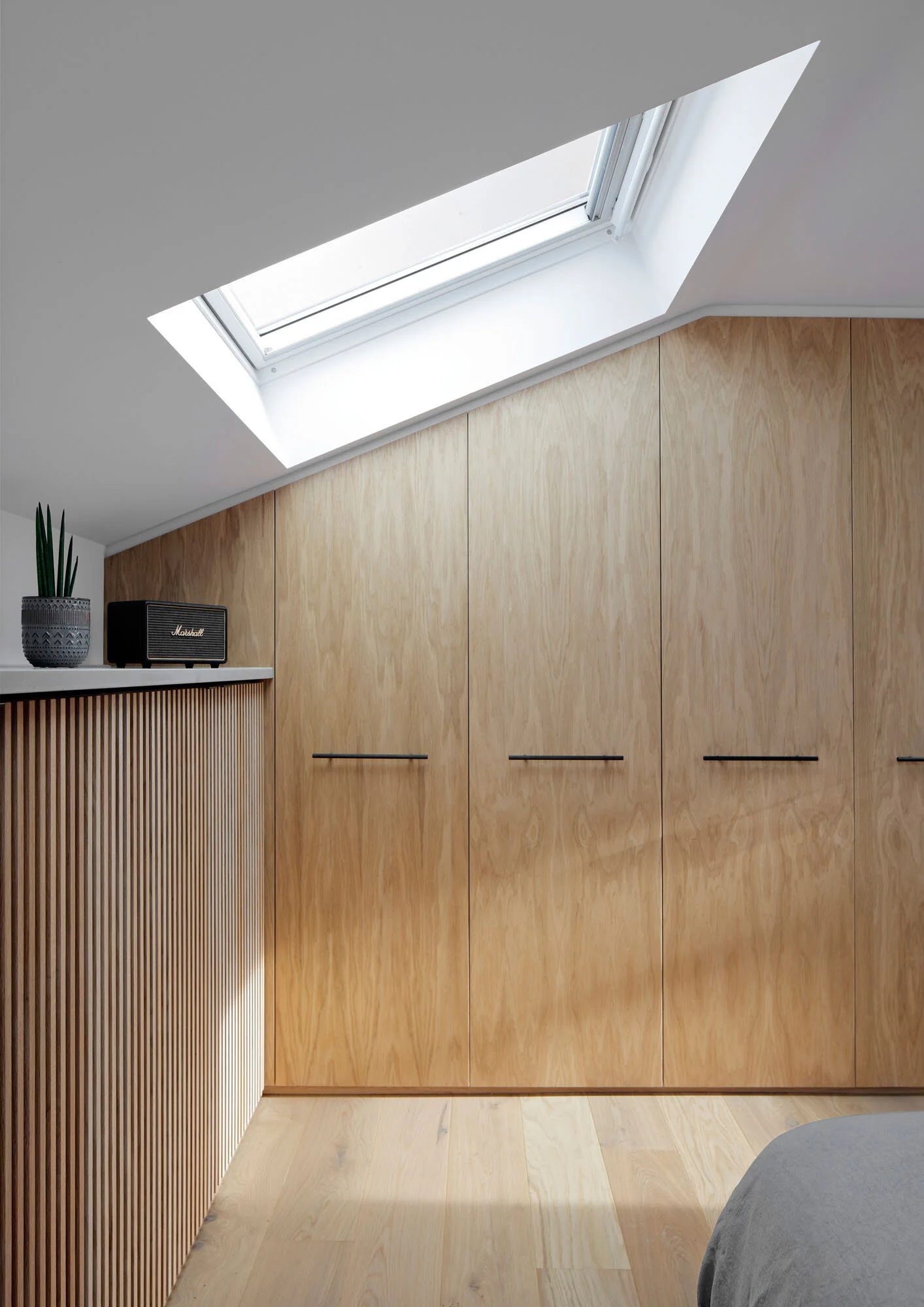 Loft bedroom at Prebend Street in Islington with rooflight and bespoke oak joinery designed around roof constraints