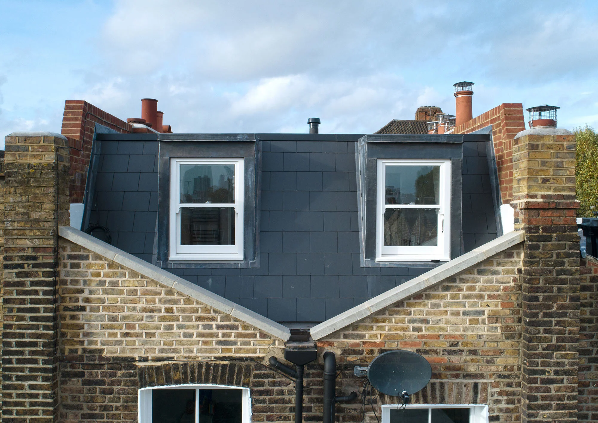 Rear mansard loft extension set behind a reinstated butterfly parapet on a Victorian terrace in Islington conservation area.