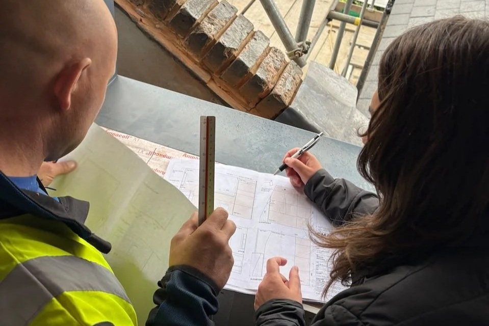 Architect and contractor reviewing technical drawings on site during a London home renovation