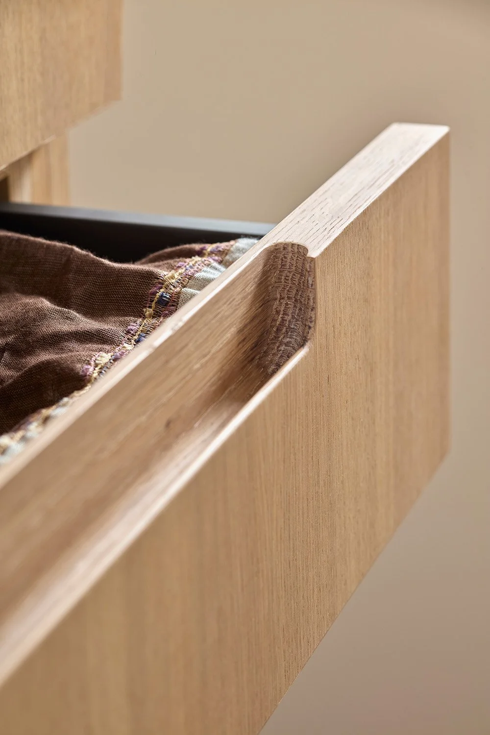 Bespoke timber wardrobe drawers and integrated storage in a modern bedroom