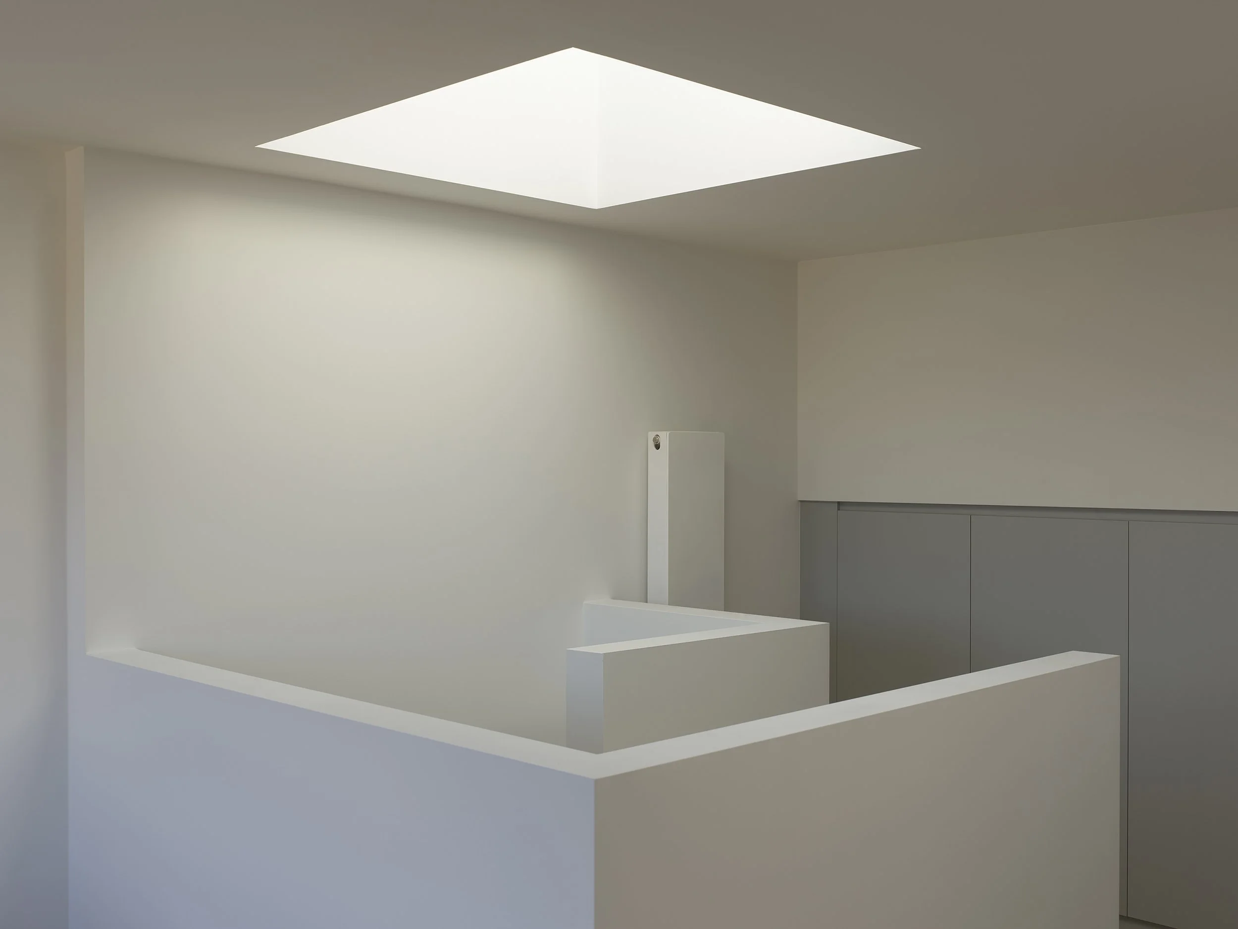 Central stair and circulation core within the roof extension, lit by a rooflight to bring daylight into the heart of the upper floor in Hackney.