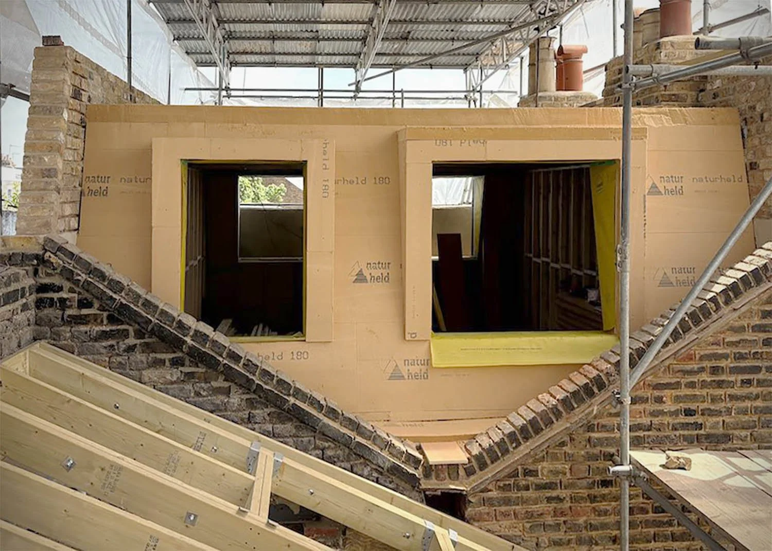 Wood fibre insulation installed continuously around a loft extension as part of a fabric-first retrofit