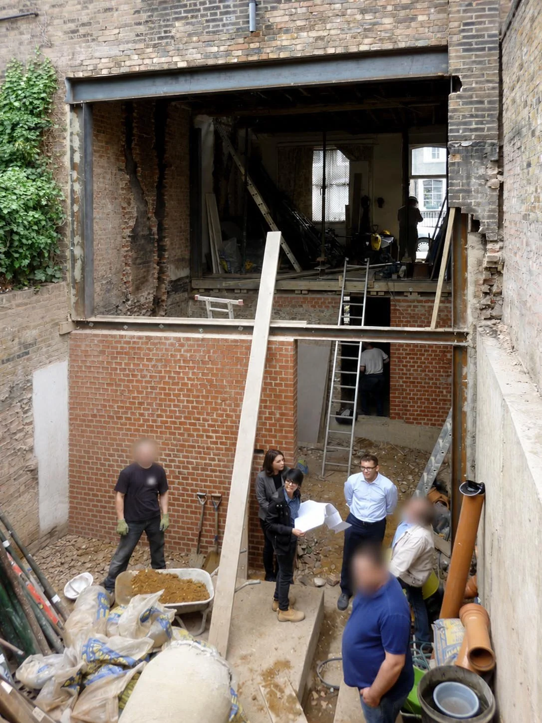 Design team inspecting basement extension works during construction of a Victorian London house renovation