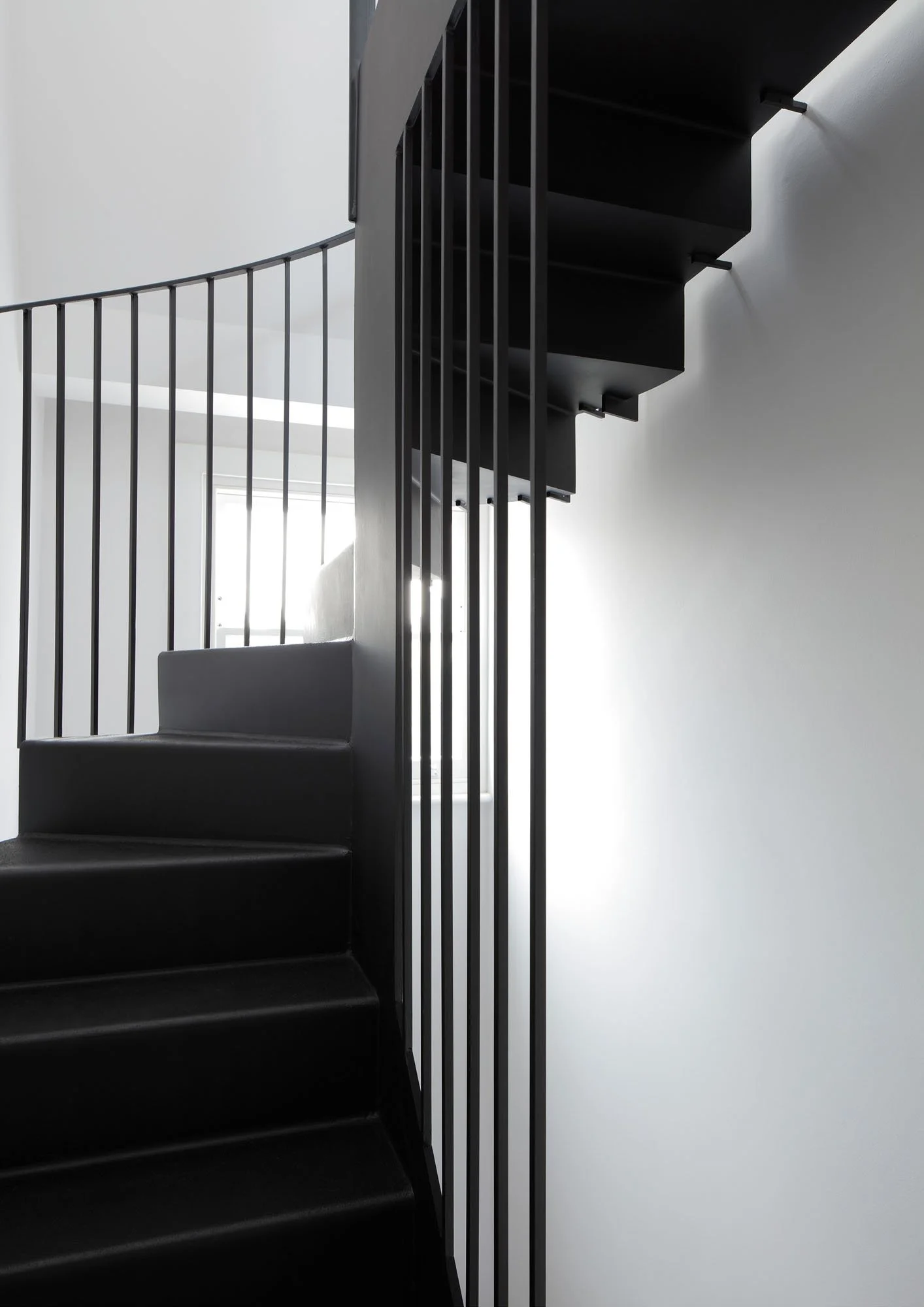 Black steel loft stair and balustrade at Prebend Street Islington showing light movement and compact-space design