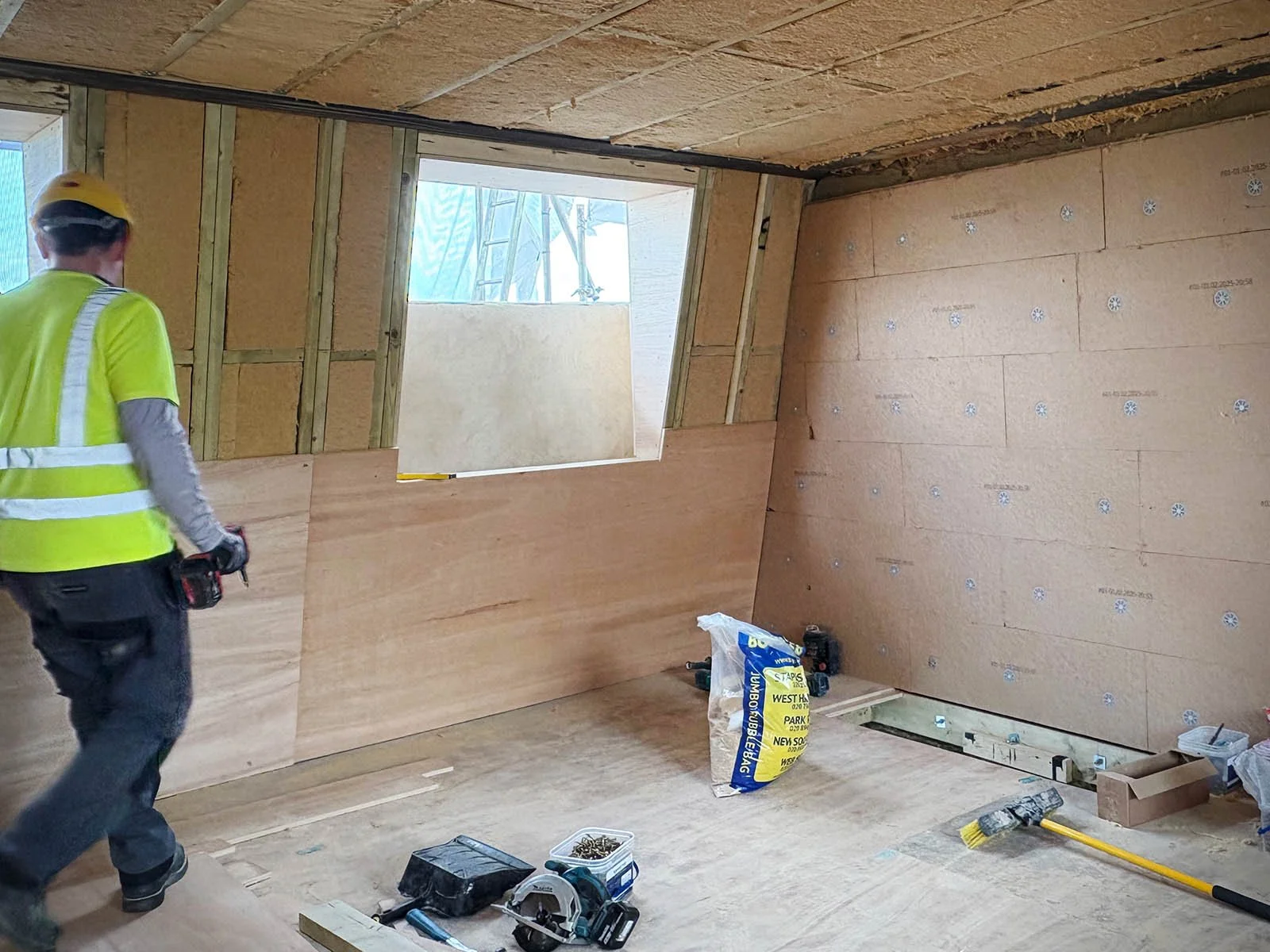Wood-fibre insulation installed across wall and ceiling junction in a mansard loft retrofit in Lower Clapton, Hackney.