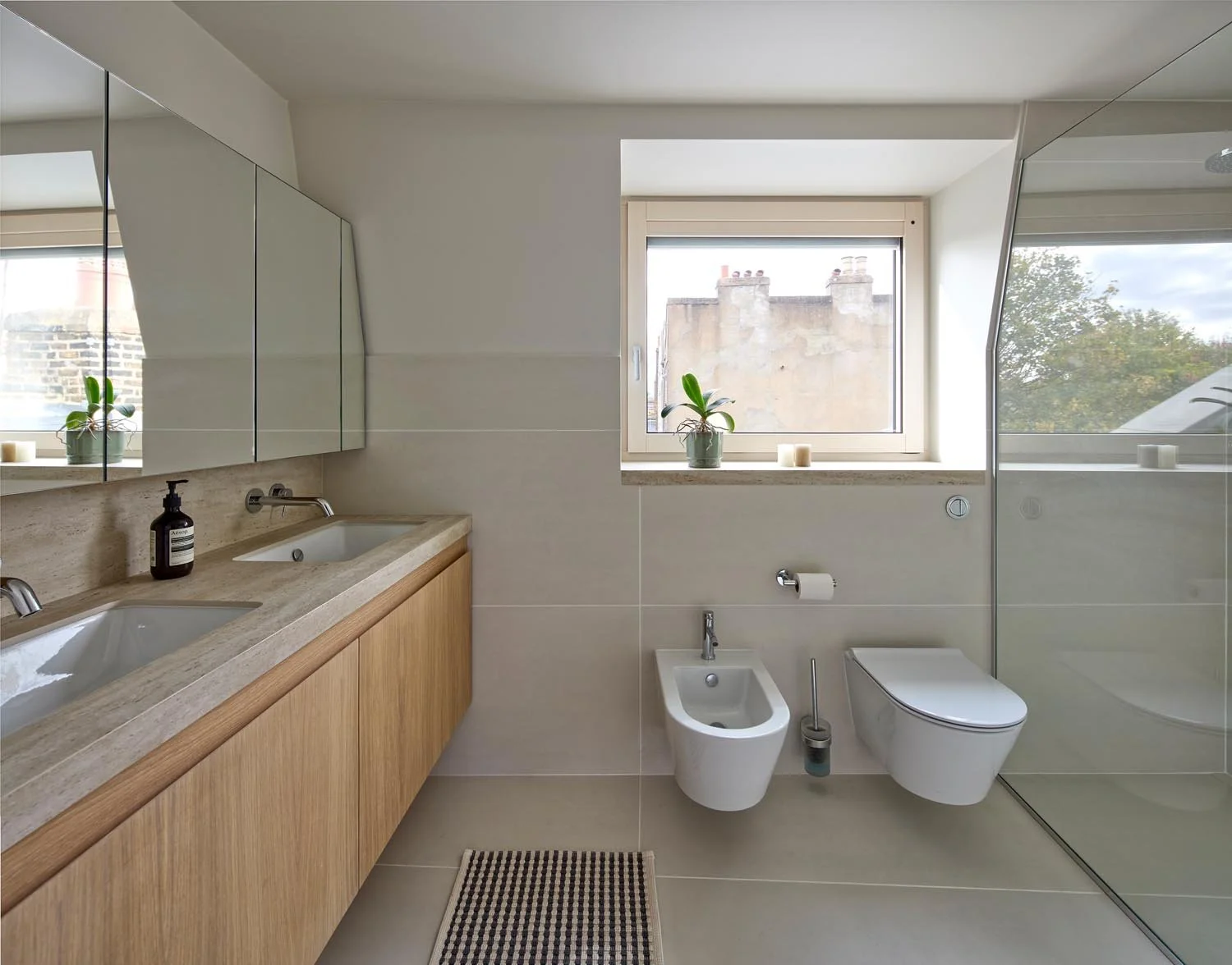 Calm London bathroom with timber vanity, large mirror, natural light and carefully coordinated fittings.