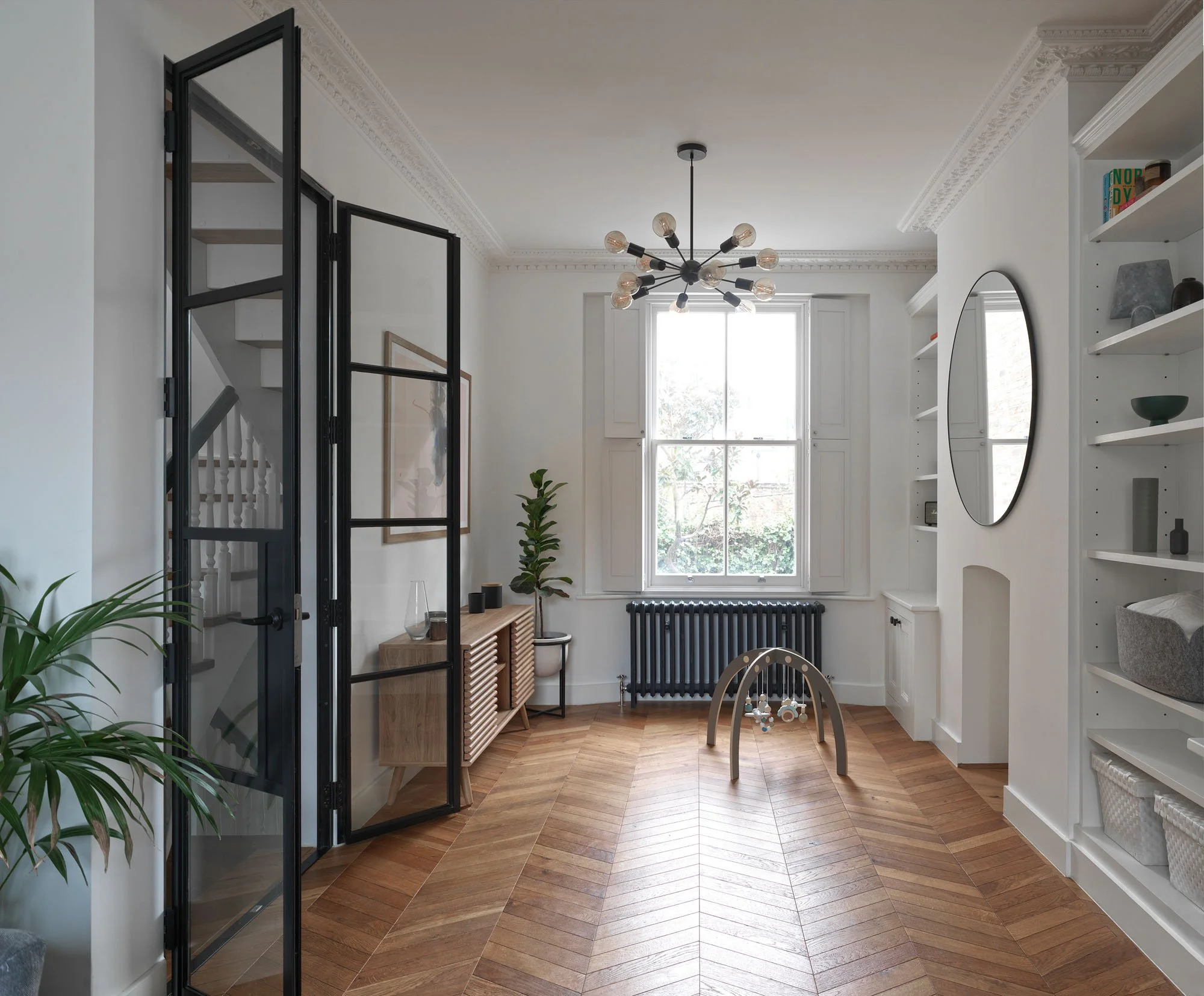 Open glazed fire doors in a Prebend Street Victorian home, preserving light and connection between rooms.