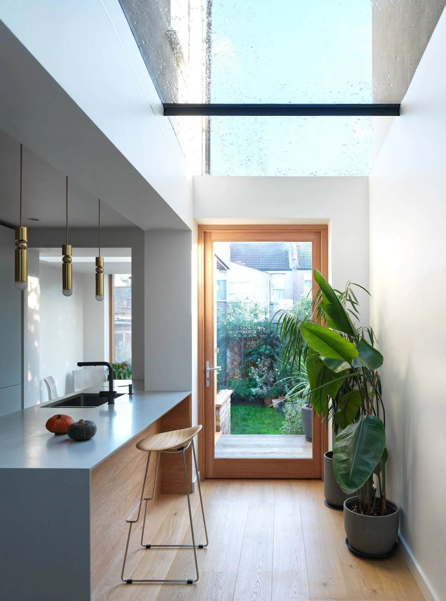 Glazed side-infill extension creating a route past the kitchen island towards the garden