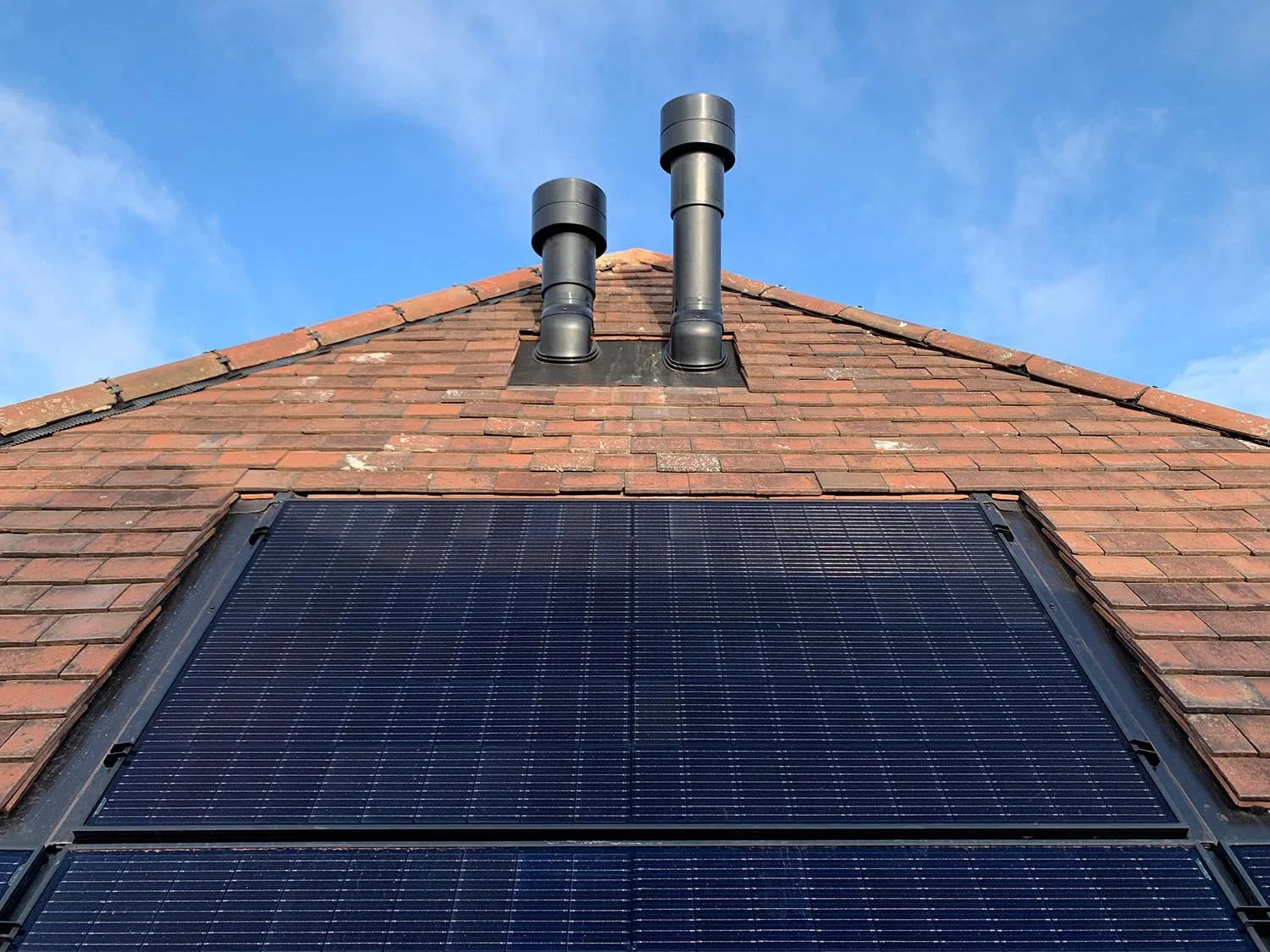Solar PV panels and MVHR roof terminals on The Orchard, an interwar semi-detached house retrofit in North London