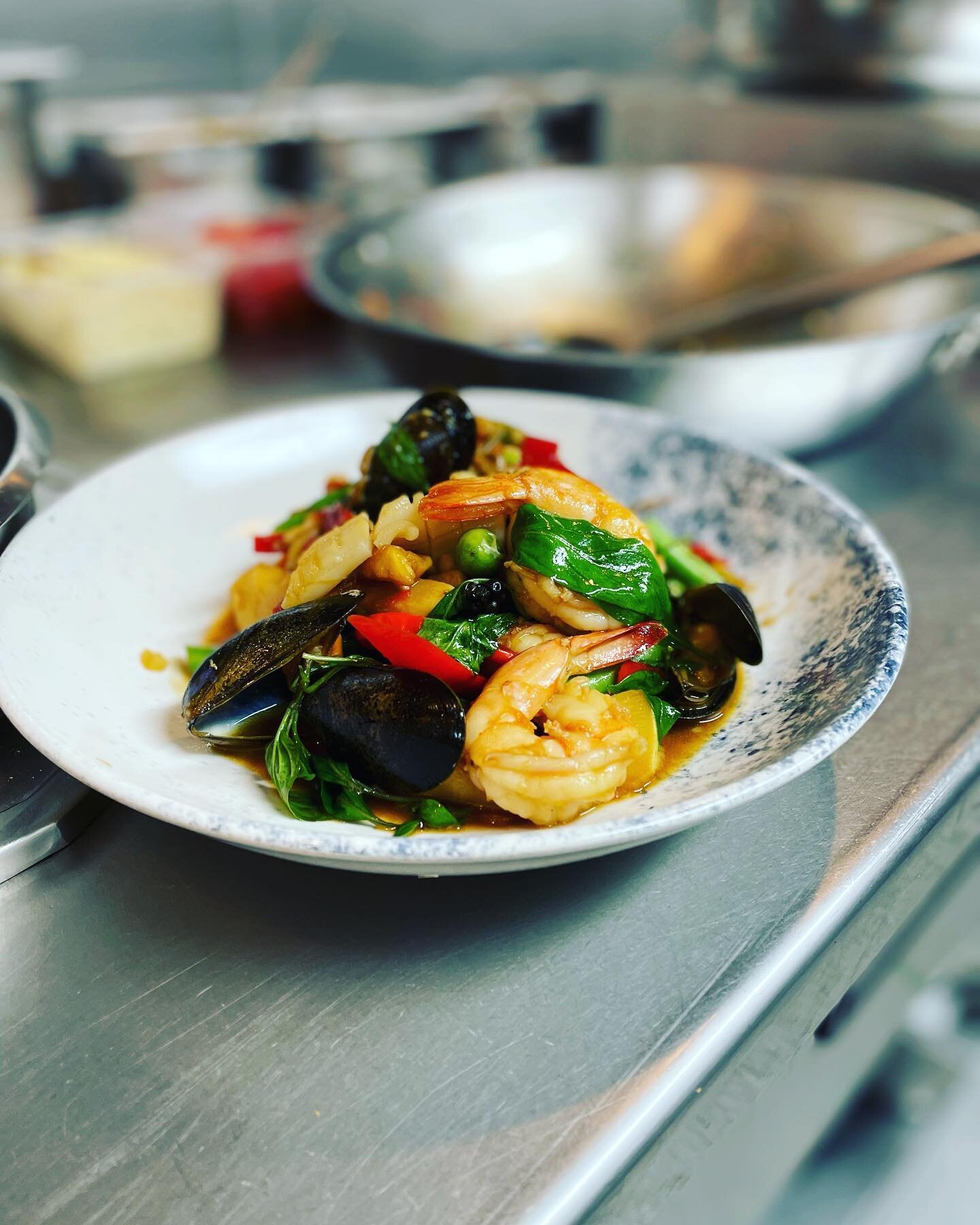 Pad Chaa Ta Lay, stir fried seafood with Kra chai ginger, chilli, garlic, sweet basil and pea aubergines.
