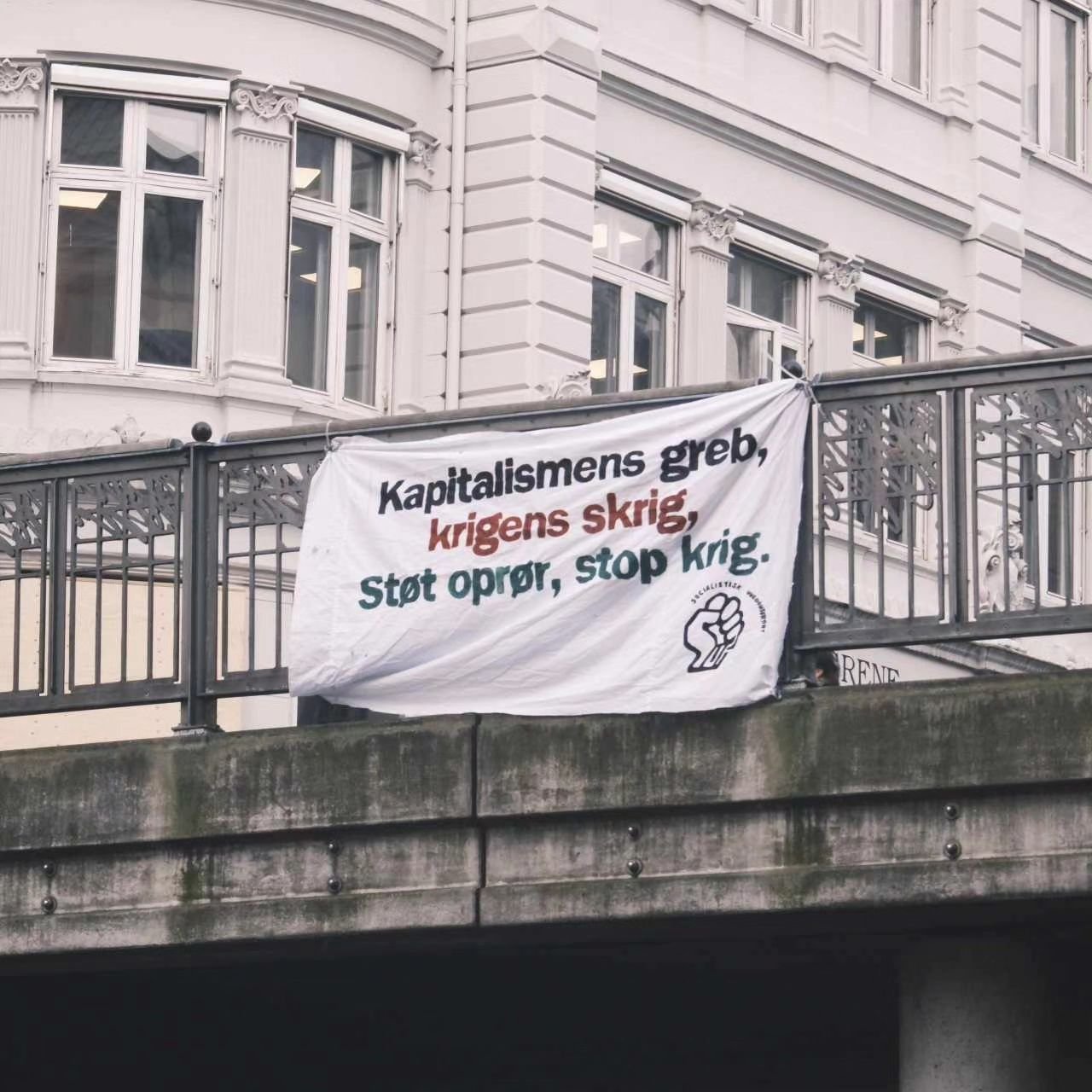 I de fleste store byer i Danmark, har man i dag kunne se et banner fra Socialistisk UngdomsFront med teksten &quot;St&oslash;t opr&oslash;r, Stop krig&quot;. Vi kender medierne godt nok til at vide, at vi vil blive skudt i skoene at st&oslash;tte Ham