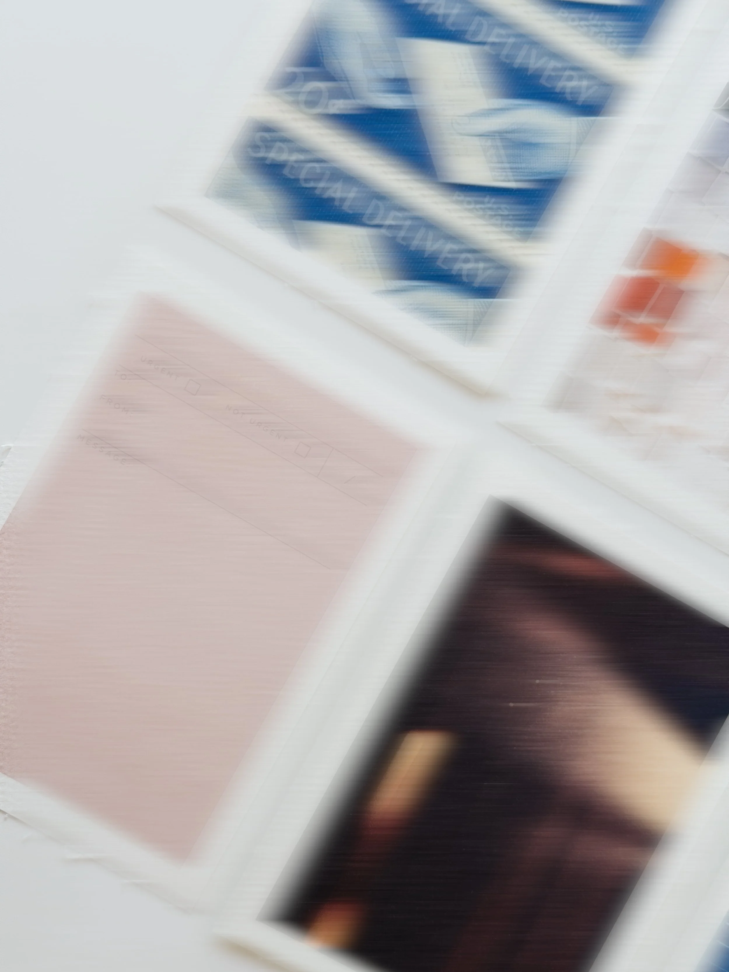 Blurred image of a person sitting at a desk with papers and books, possibly studying or working.