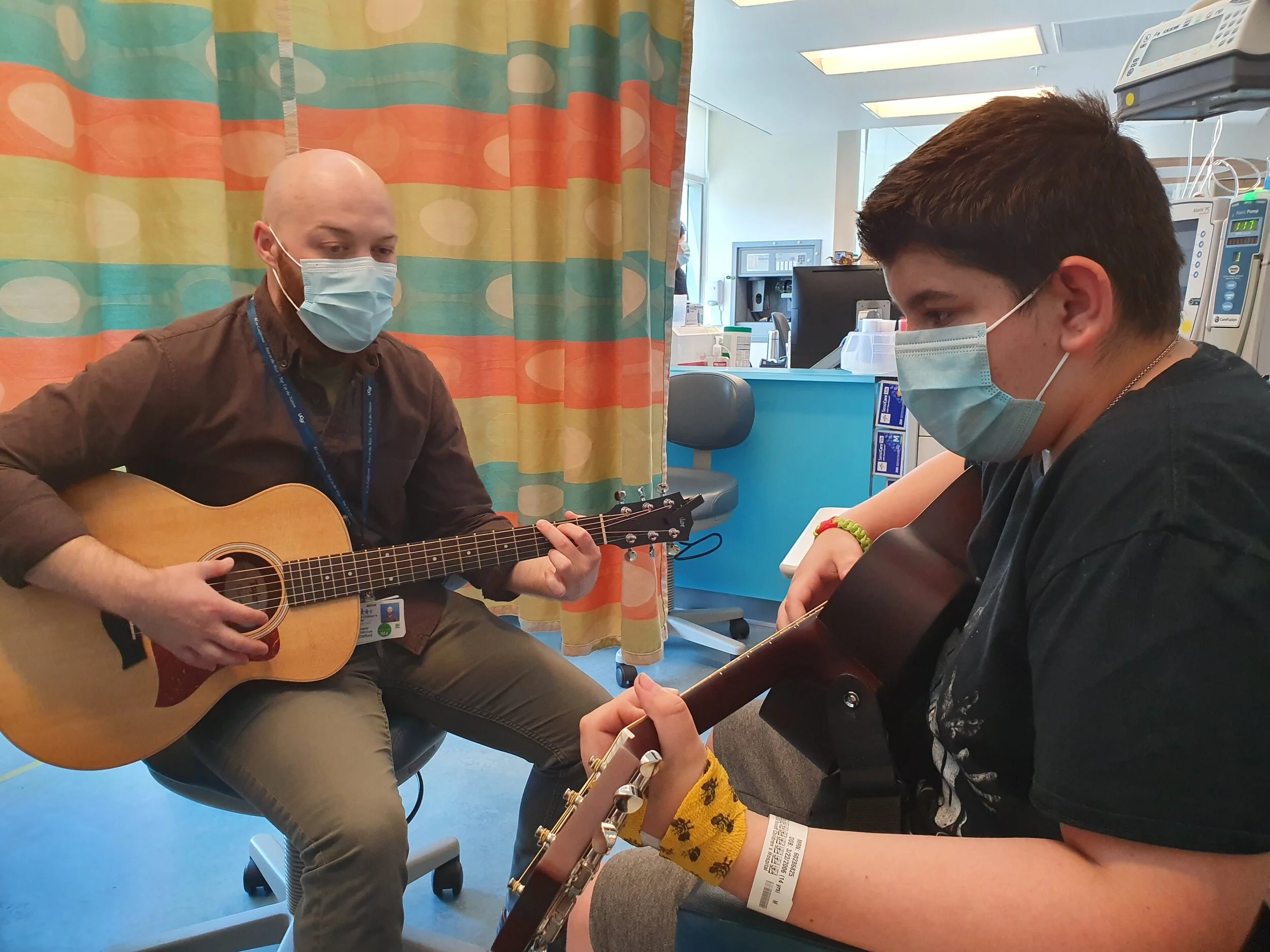 Bobby learning to play the guitar during an infusion treatment at UCSF Benioff Children’s Hospital’s Pediatric Infusion Center.