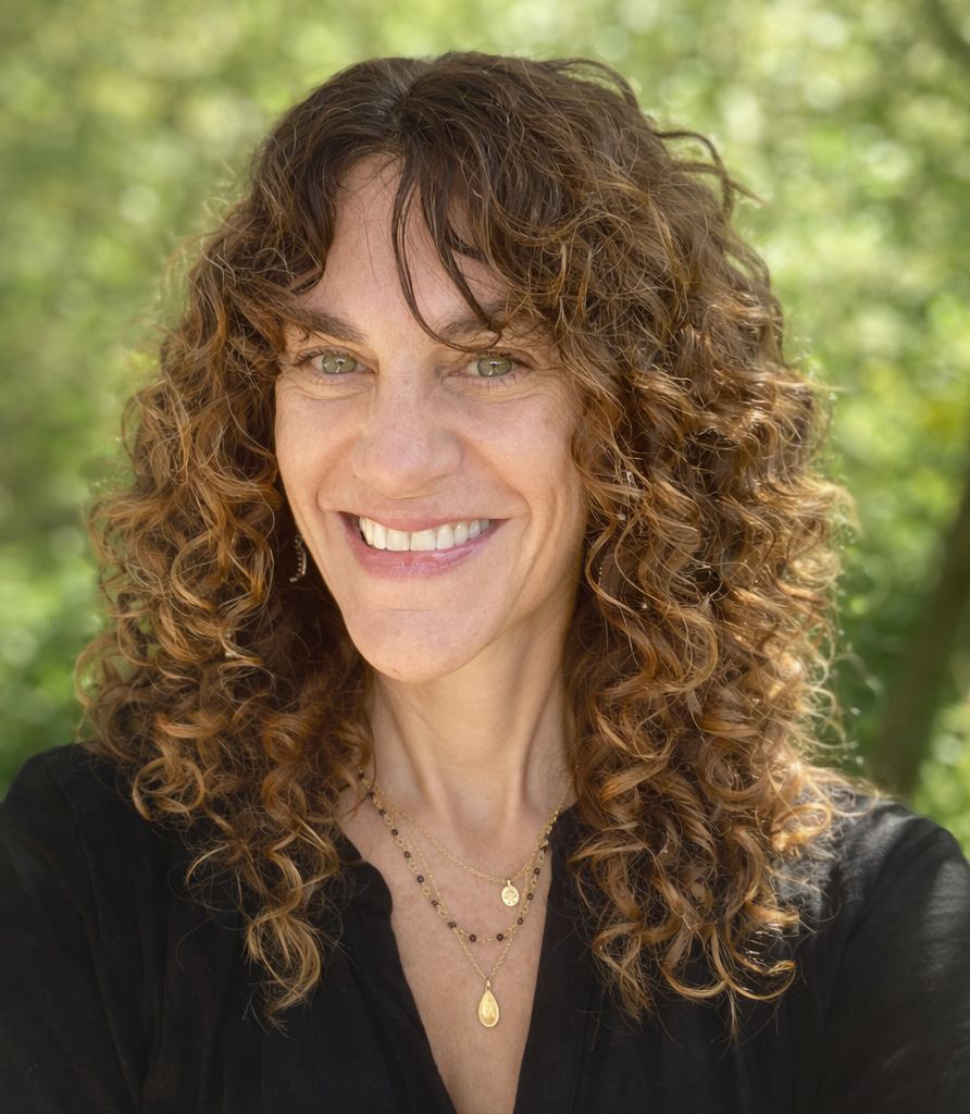 Meryl Fields smiling and sitting outdoors.