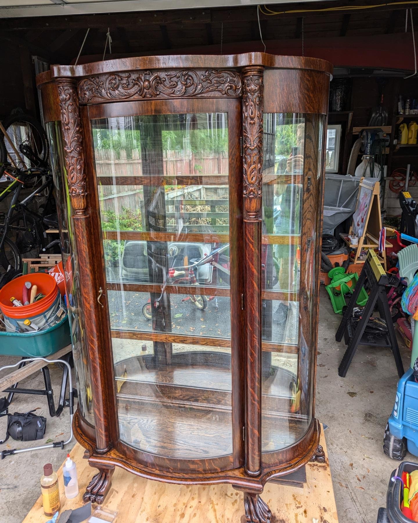 Antique oak cabinet restored. The handmade curved glass panels are incredible. I had to glue down lots of loose veneer and patch in some areas that were missing. The last two photos show some of the repairs. The original finish was shellac and, after