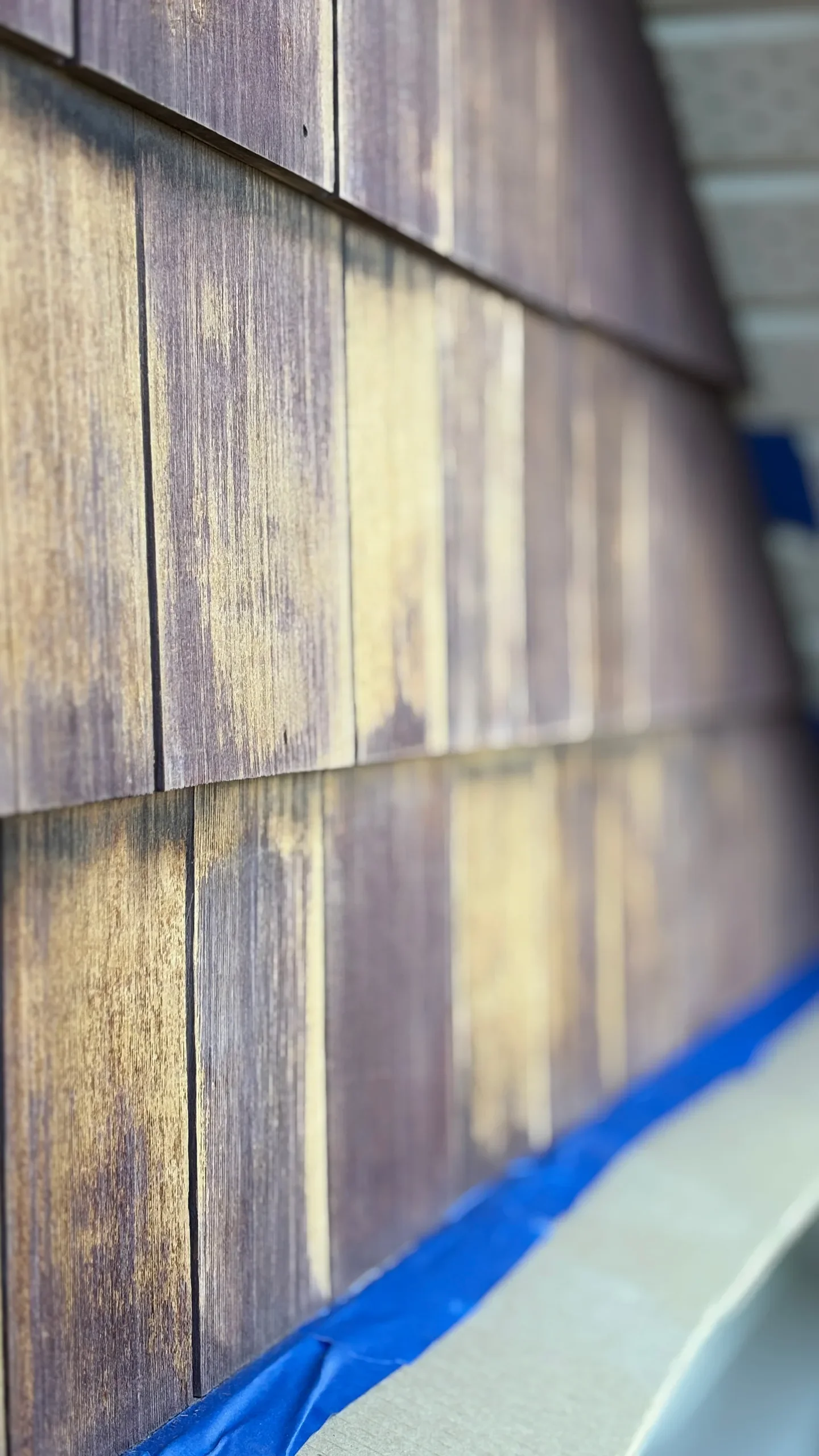 Close-up of a wooden wall or paneling with a blue protective cover and beige surface below.
