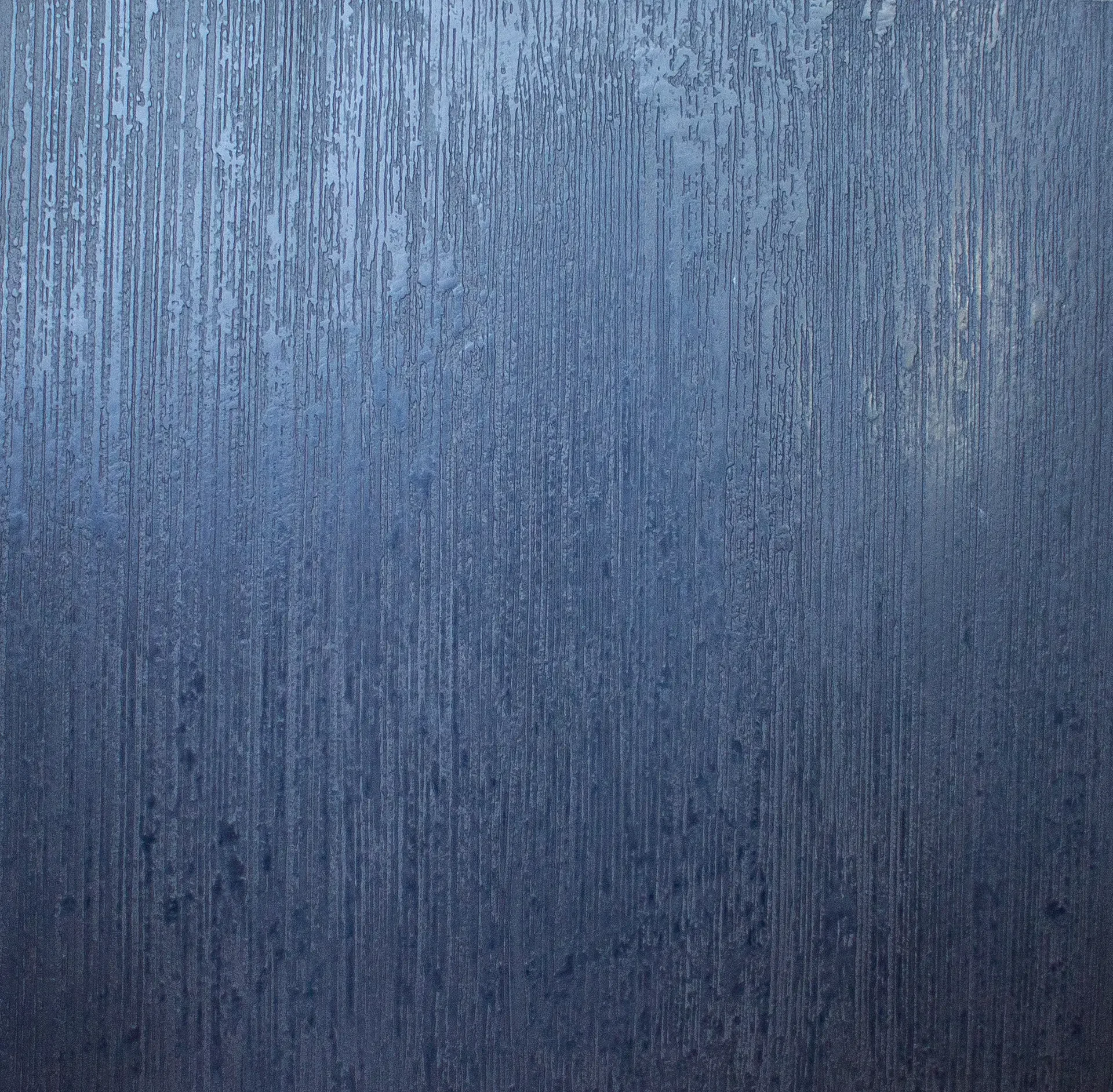 Close-up of a blue wooden surface with visible vertical grain and water droplets.