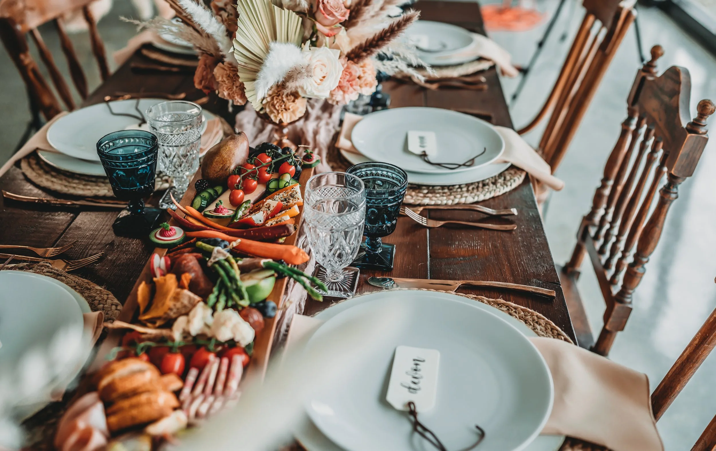 A considered event table with layered place settings and abundant food