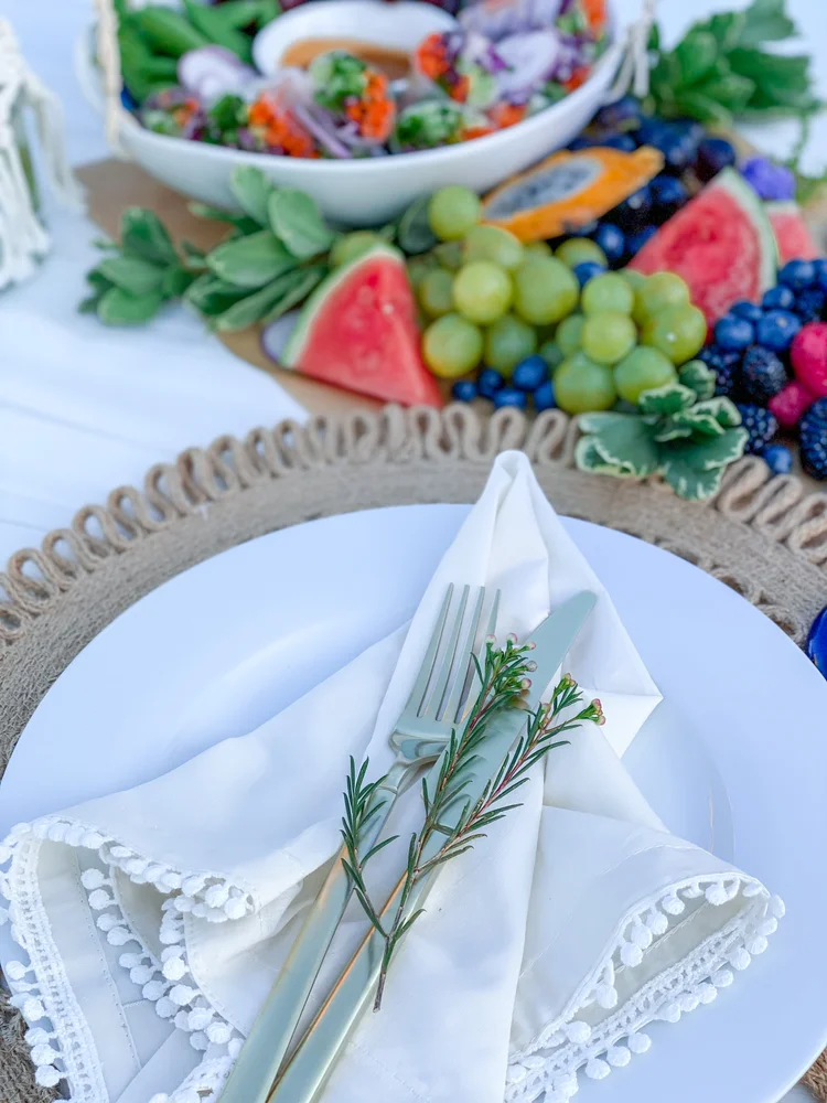 Basic white dinner plate shown as part of a place setting; linens pictured are not included.